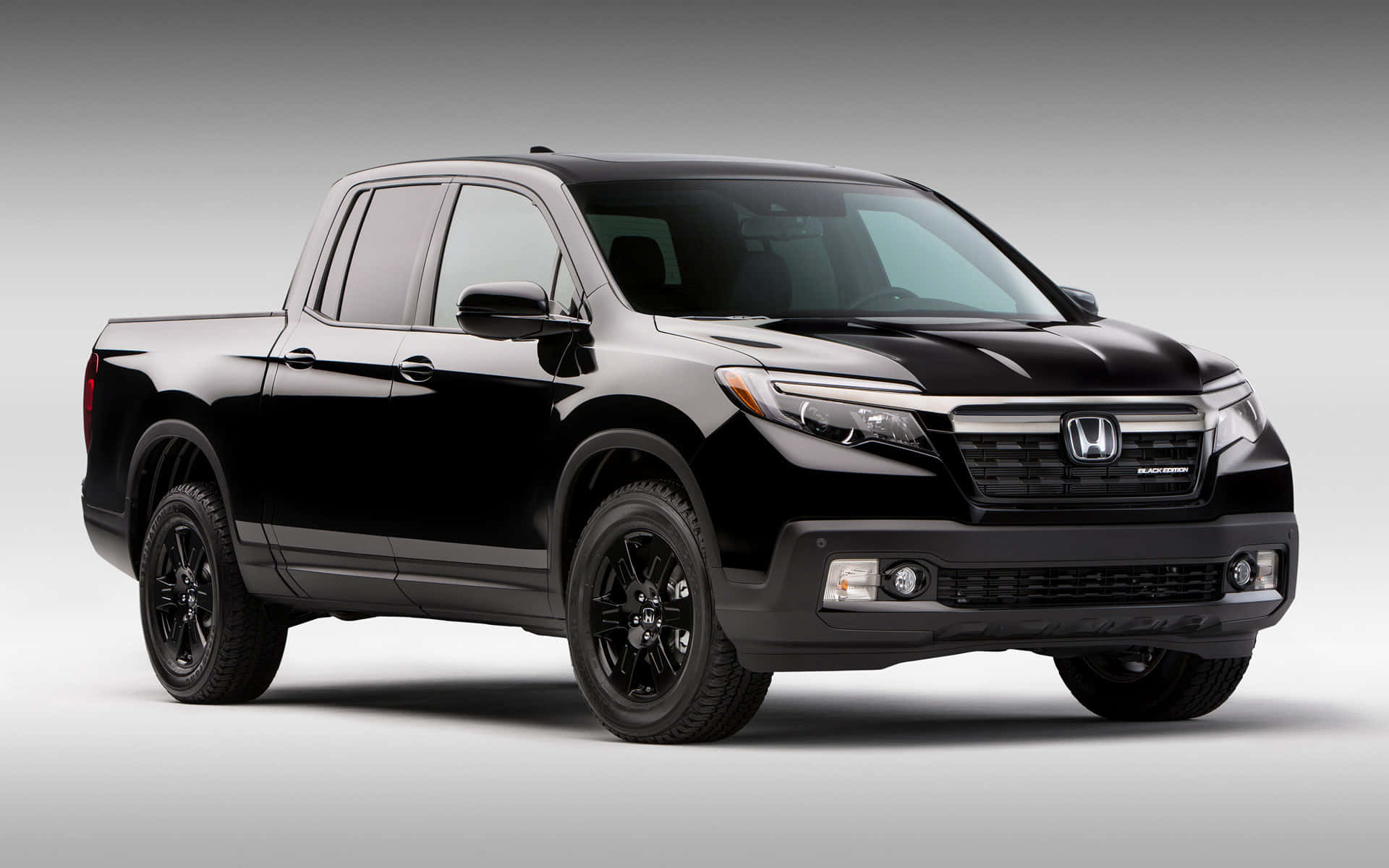 Honda Ridgeline 桌布 壁紙 — 一輛時尚的黑色本田Ridgeline皮卡車在工作室燈光下展示，背景為簡約灰色。