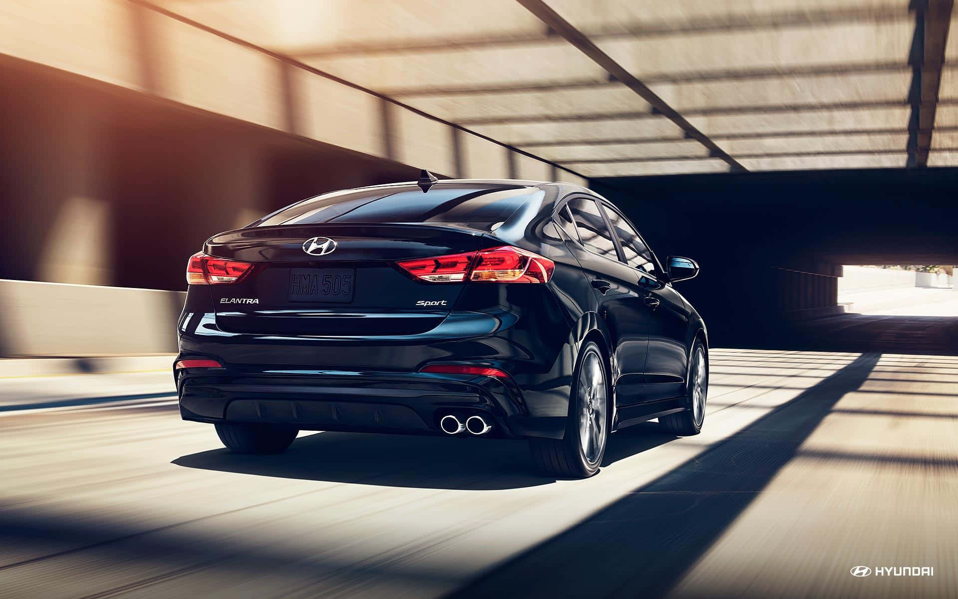 Hyundai Elantra 桌布 壁紙 — 一輛時尚的黑色現代伊蘭特在陽光照射的隧道中疾馳，動態模糊強調了速度。