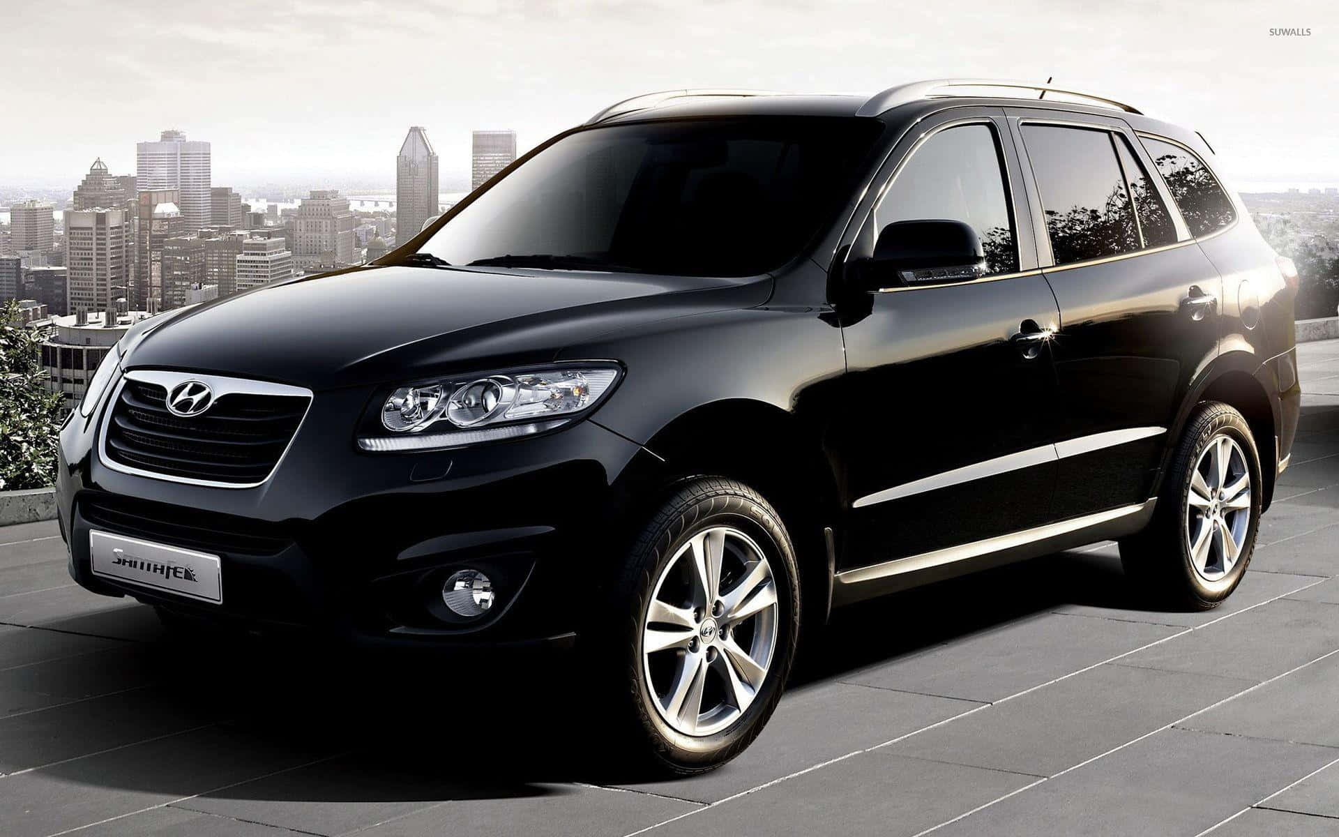 Hyundai Santa Fe 桌布 壁紙 — 一輛時尚的黑色現代Santa Fe SUV停泊在瓷磚屋頂上，背景是城市天際線。