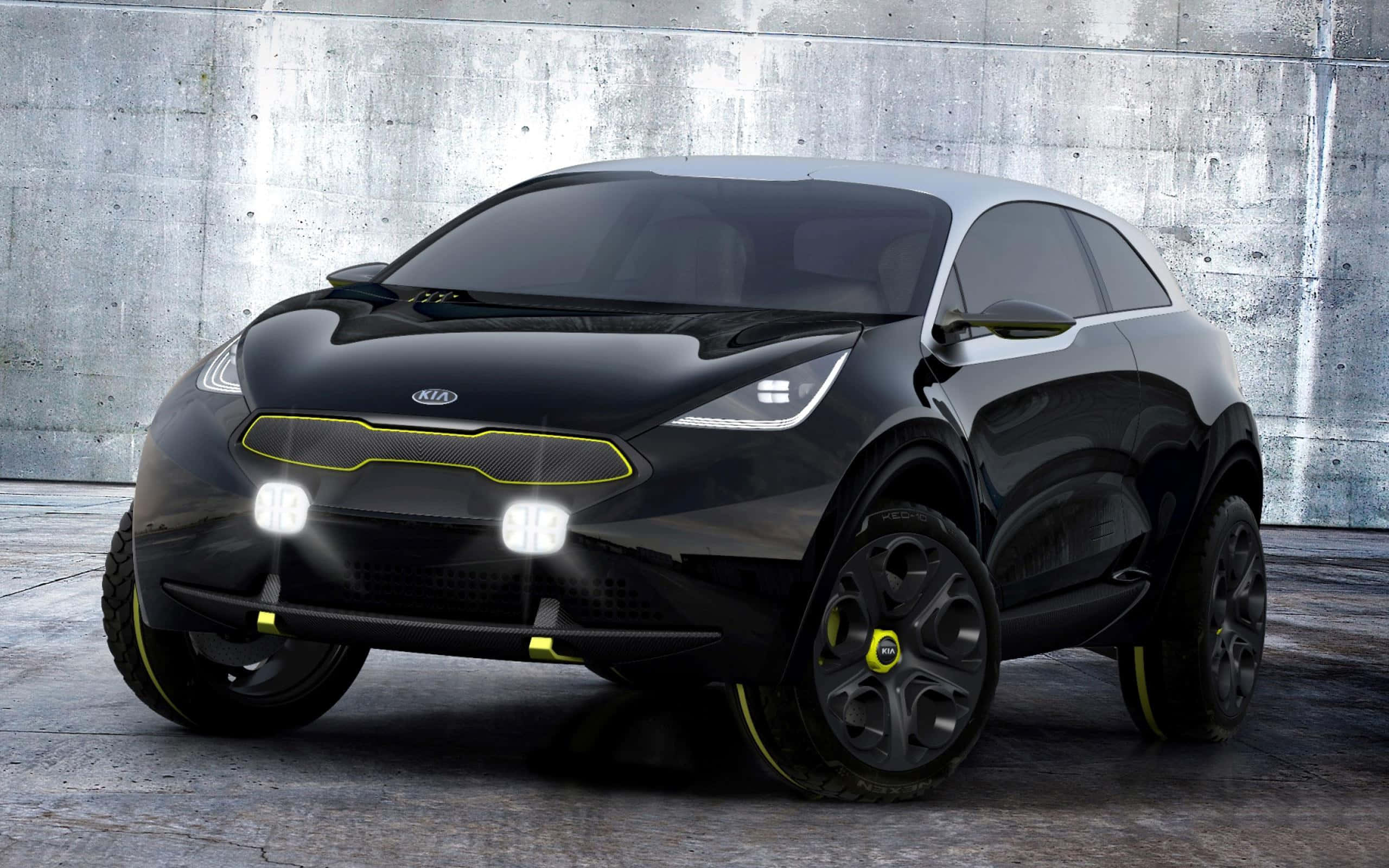 Kia Niro 桌布 壁紙 — 一輛時尚的黑色起亞概念車，帶有發光的黃色點綴，停在有紋理的混凝土牆前。