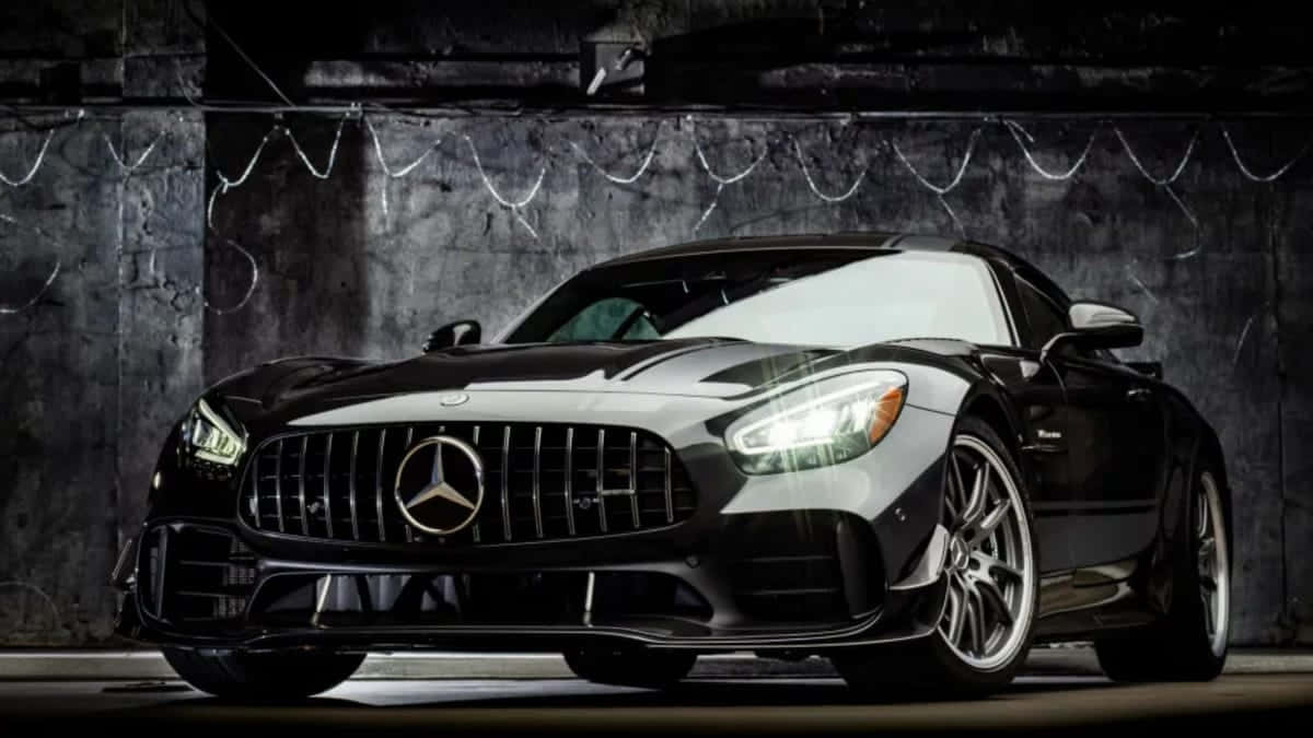  壁紙 — 一輛時尚的黑色Mercedes-AMG GT跑車在粗獷的地下車庫中，在戲劇性的燈光下閃閃發光。