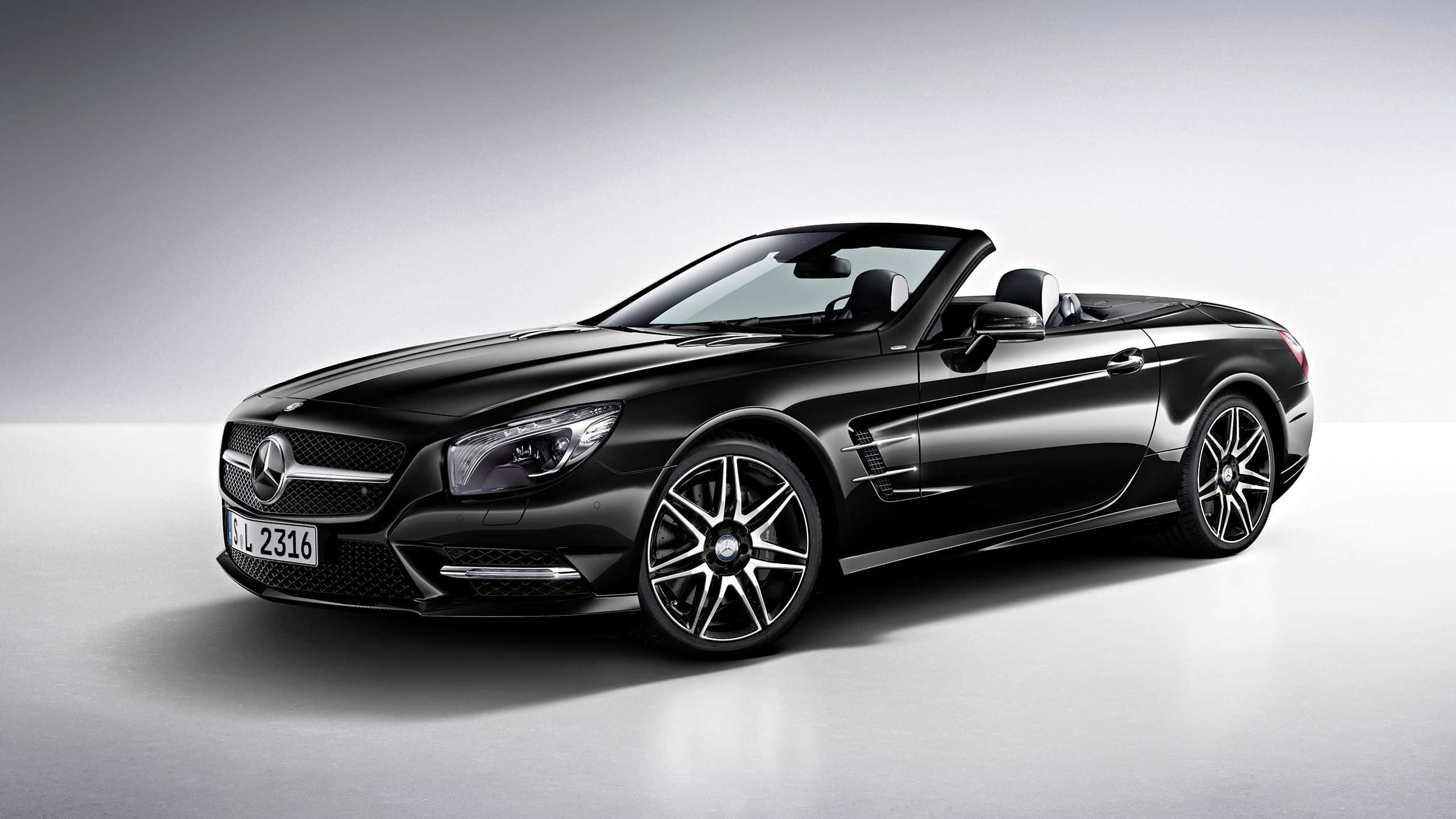 Mercedes Benz Sl-class 桌布 壁紙 — 一輛時尚的黑色梅賽德斯 SL 開篷跑車配銀色輪圈，在簡約的攝影棚環境中展示。
