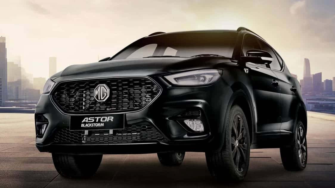  壁紙 — 一輛時尚的黑色MG Astor Blackstorm SUV在黃金時刻的朦朧城市天際線前展示。