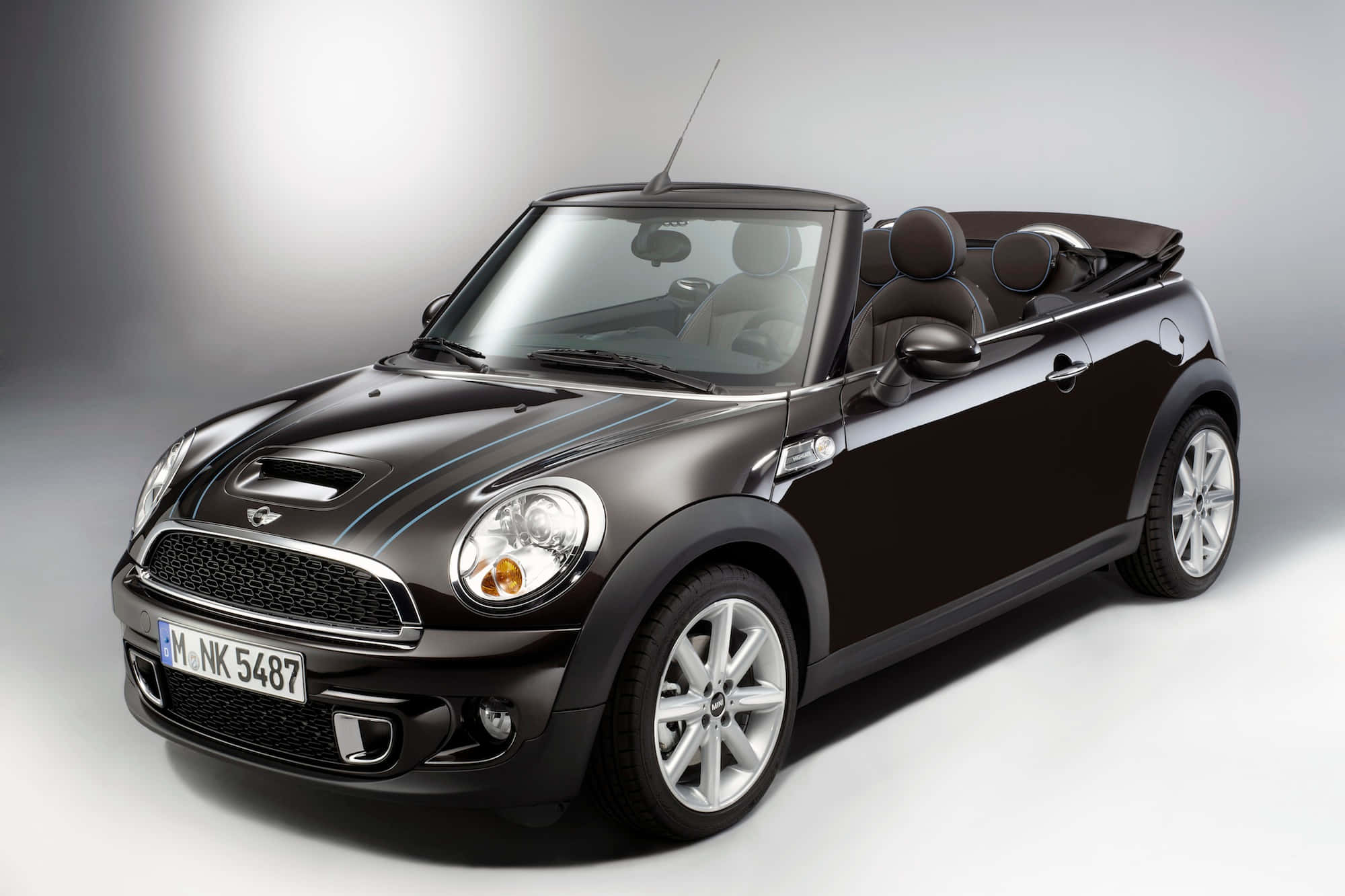 Mini Cooper Convertible 桌布 壁紙 — 一輛時尚的黑色MINI Cooper開篷車，配備銀色輪圈和軟頂，在漸變灰色背景的攝影棚中擺拍。