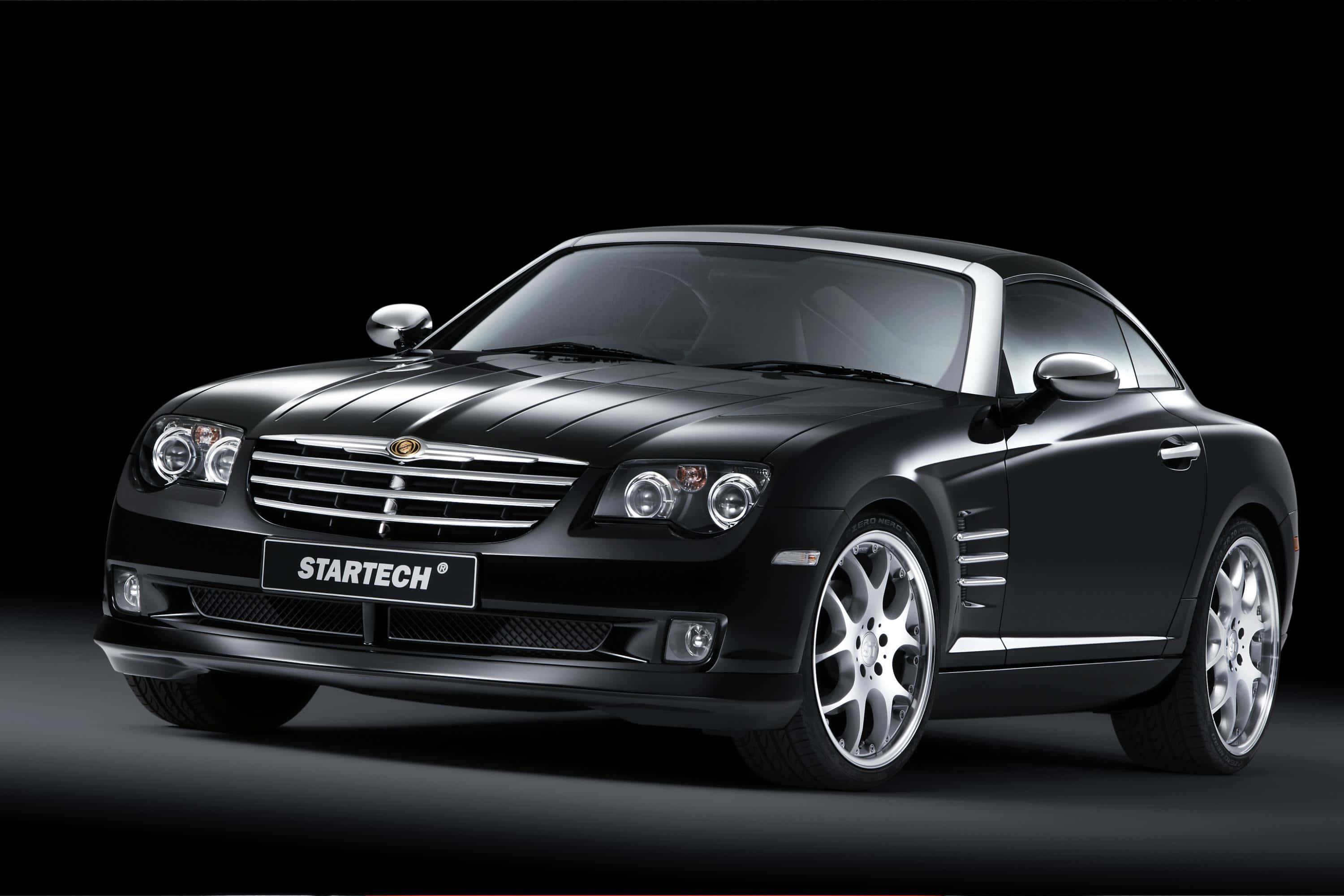 Chrysler Crossfire 桌布 壁紙 — 一輛時尚的黑色Startech跑車，帶有銀色飾邊和定制輪轂，在黑暗背景的攝影棚燈光下閃耀。