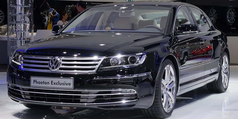  壁紙 — 一輛時尚的黑色福士偉根Phaeton Exclusive房車在明亮的展廳燈光下閃閃發光，配備鍍鉻飾件和合金輪圈。