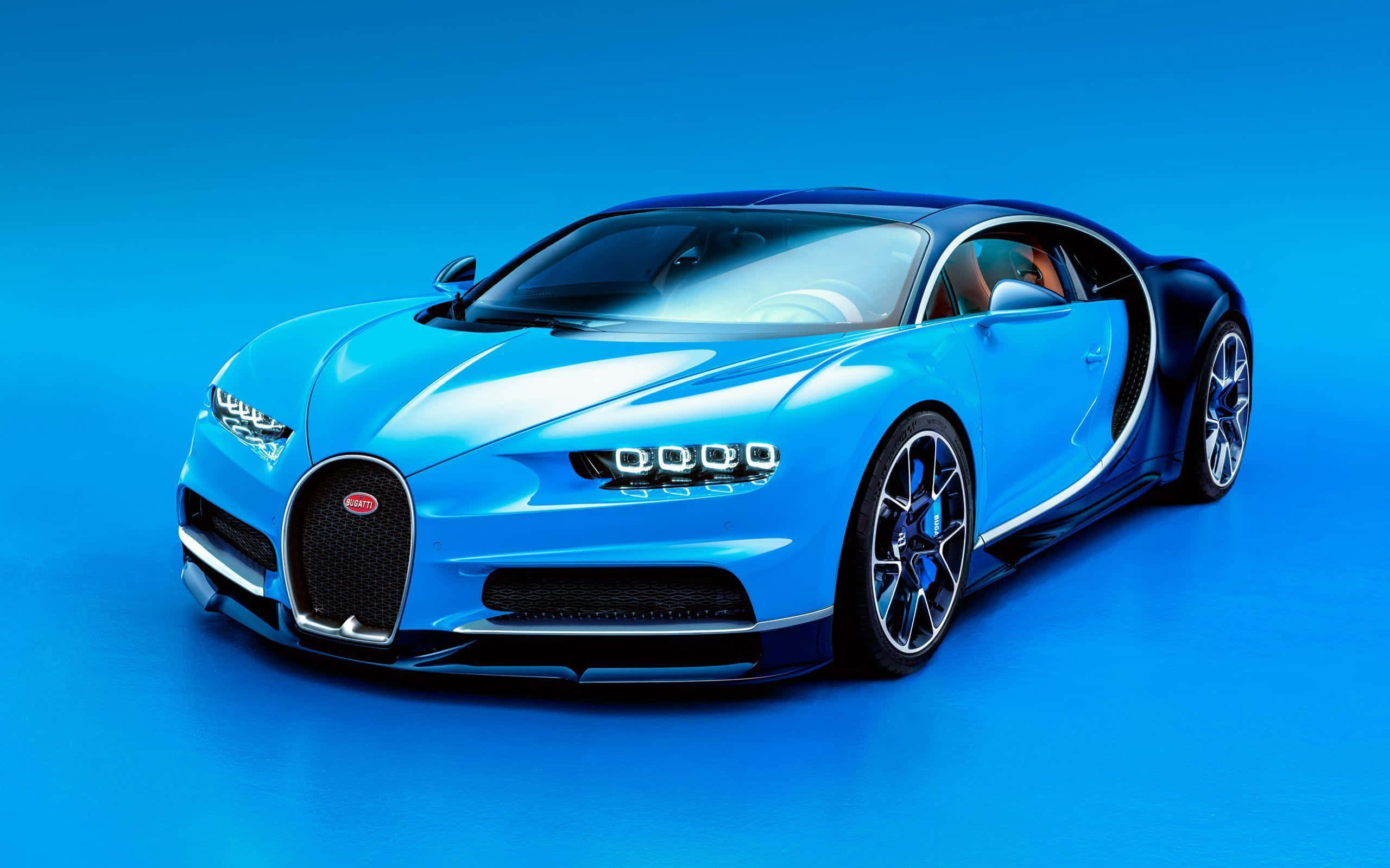 Bugatti Chiron 桌布 壁紙 — 一輛時尚的藍色Bugatti Chiron跑車在攝影棚燈光下，在純藍色背景上閃閃發光。