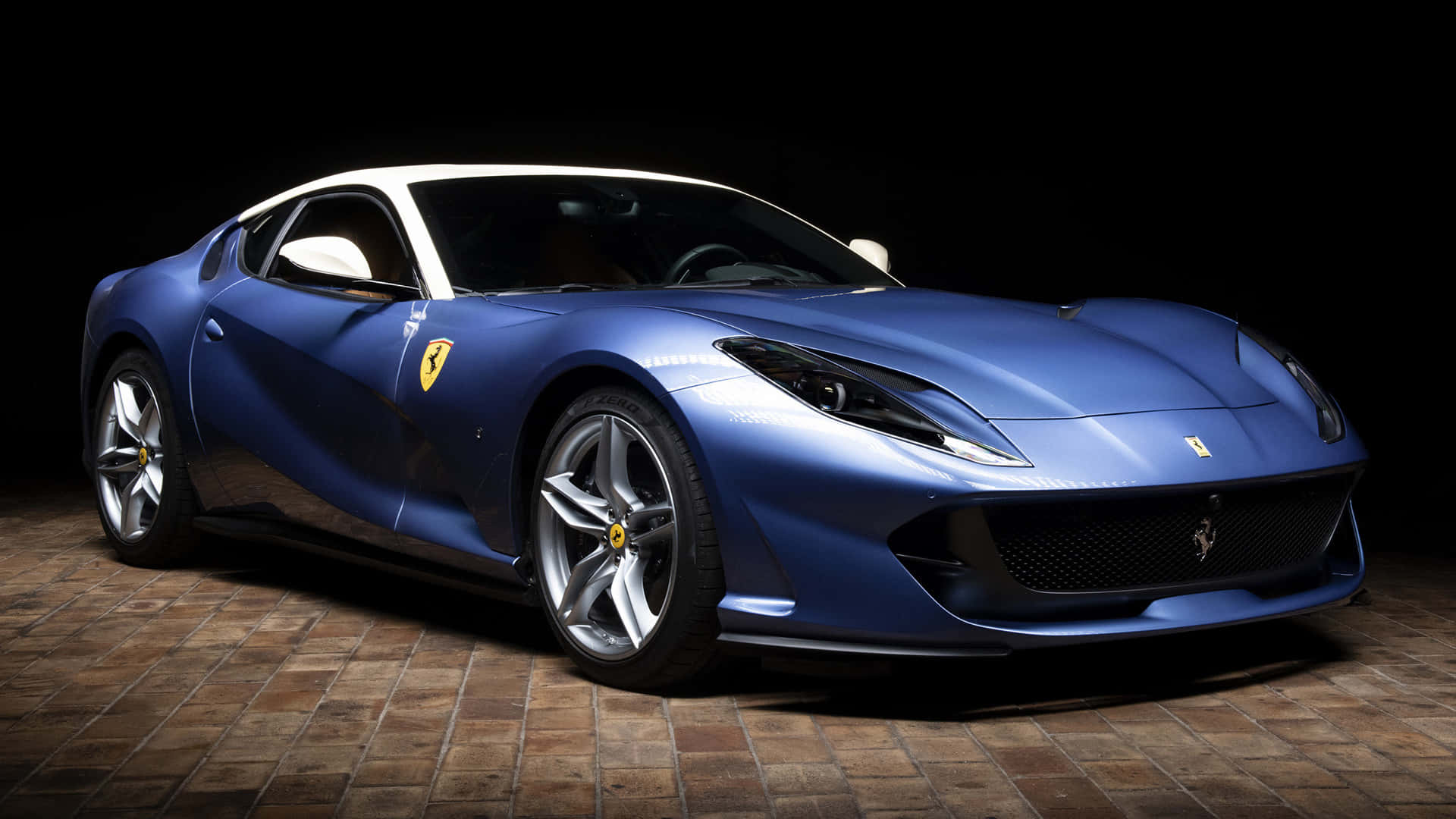 Ferrari 812 Superfast 桌布 壁紙 — 一輛時尚的藍色法拉利跑車，白色車頂，在瓷磚地板上的攝影棚燈光下閃閃發光。