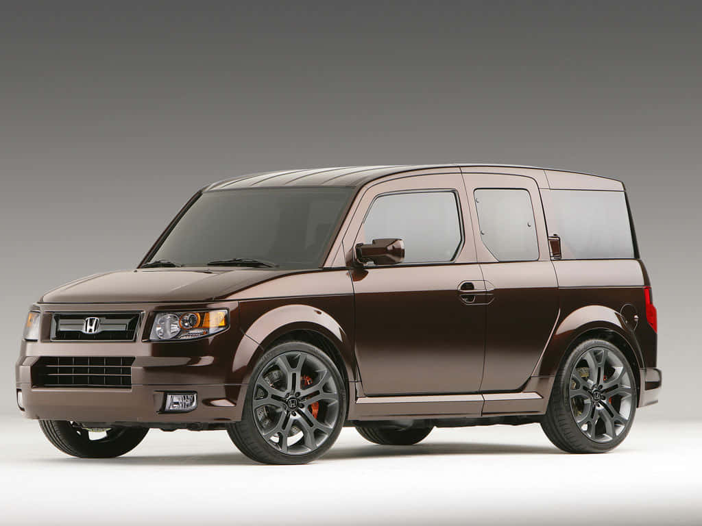 Honda Element 桌布 壁紙 — 一輛時尚的棕色本田Element，配備黑色輪圈和紅色制動卡鉗，在灰色漸變背景的工作室中展示。
