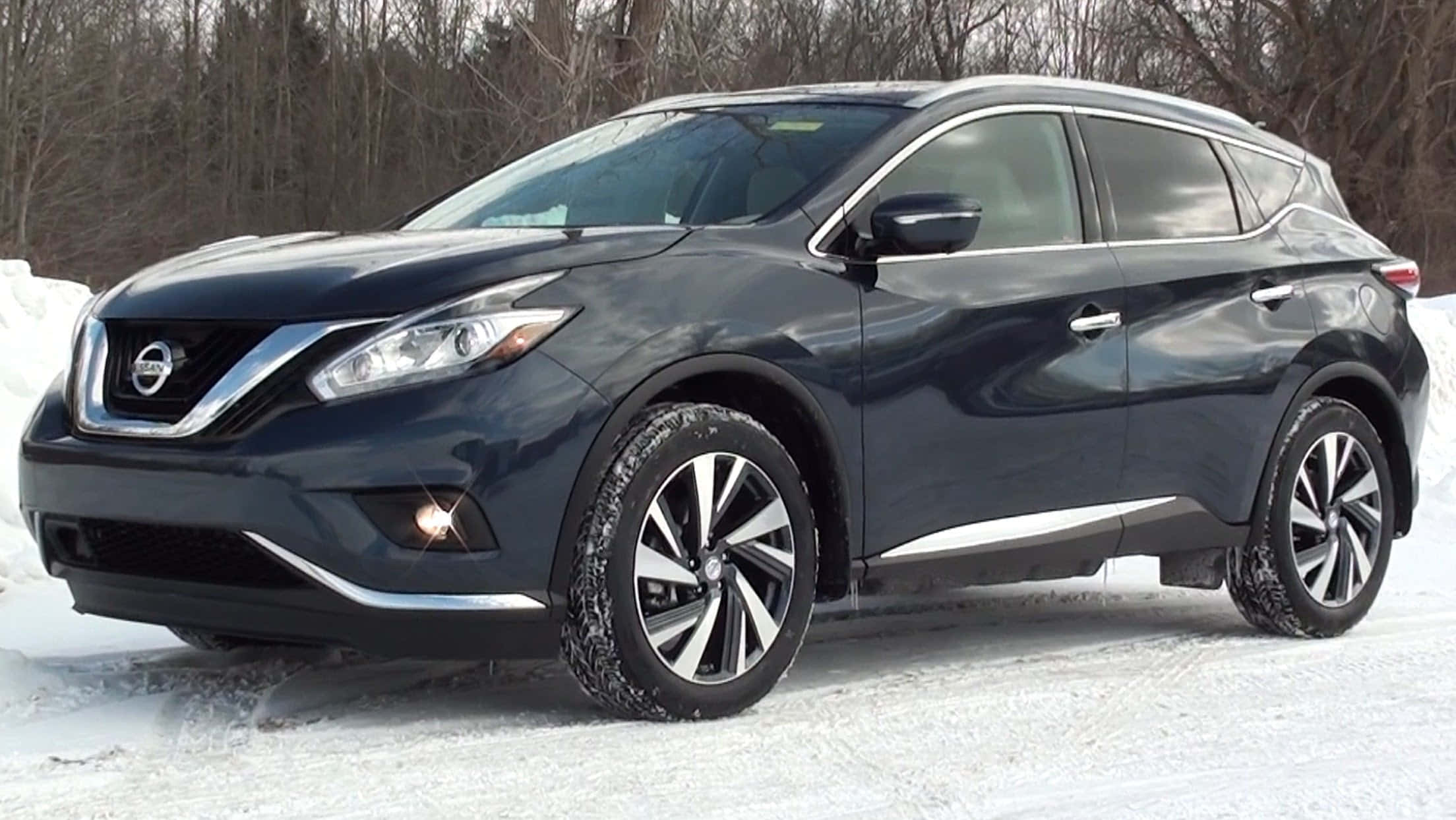 Nissan Murano 桌布 壁紙 — 一架時尚深藍色日產Murano SUV停泊在雪地上，背景有光禿禿的樹木。