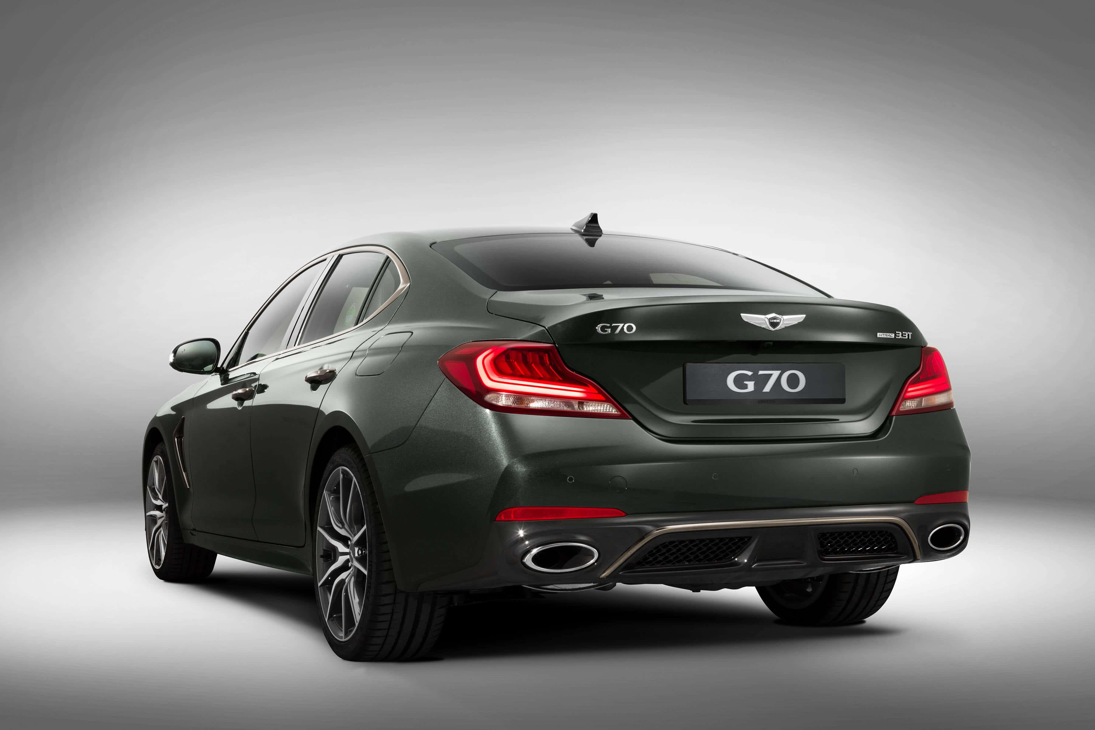 Genesis G70 桌布 壁紙 — 一輛時尚的深綠色Genesis G70轎車從後方展示，帶有發光的紅色尾燈，背景為漸變灰色工作室背景。