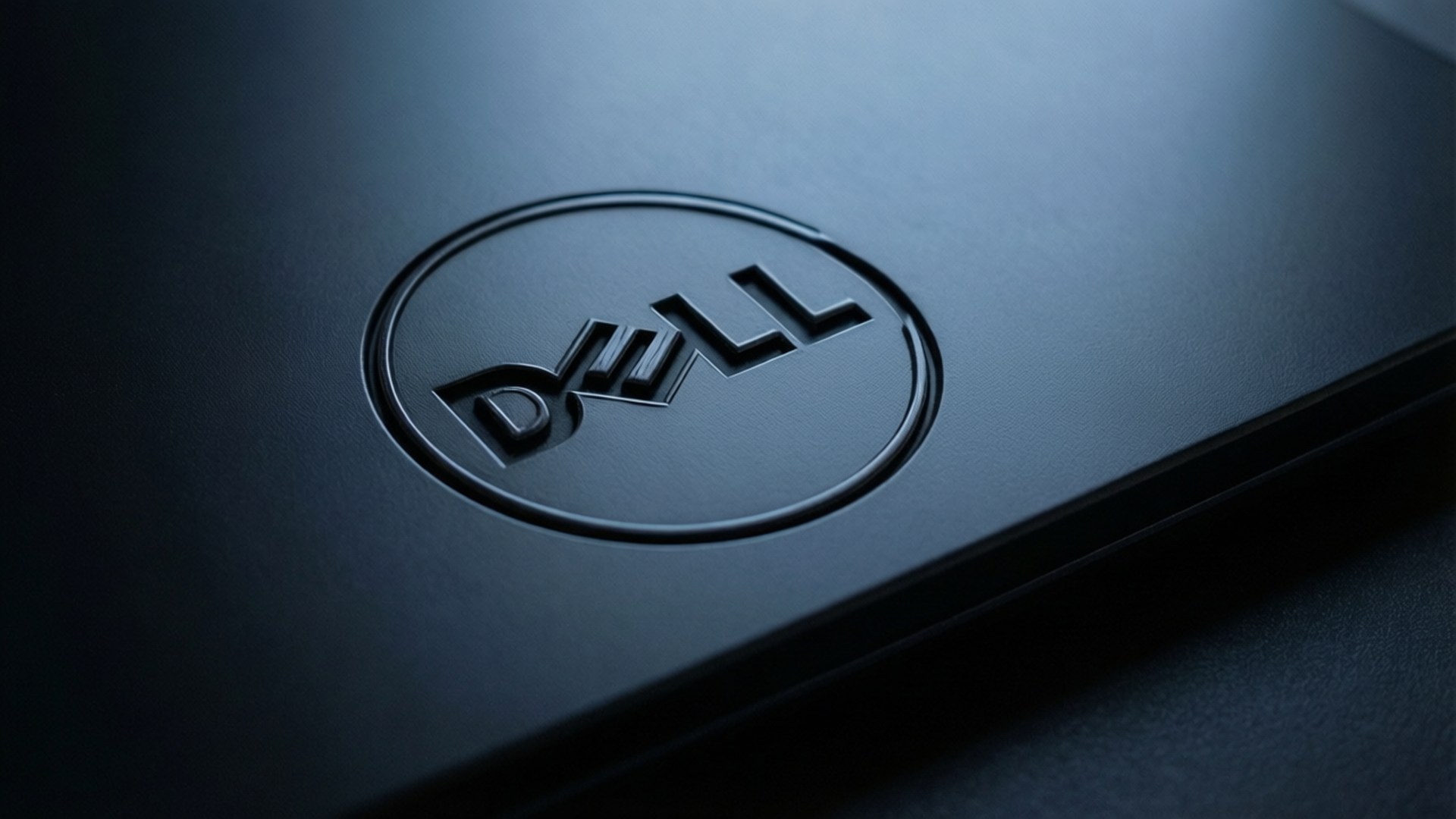 柔和燈光下黑色筆記本電腦蓋上Dell標誌特寫
