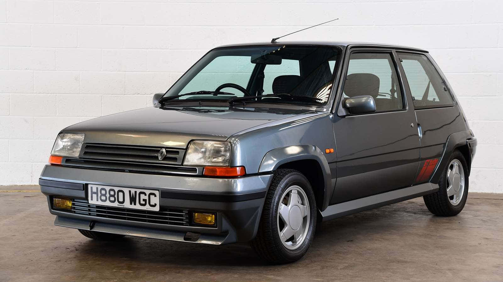 Renault 5 Turbo 桌布 壁紙 — 一架時尚的灰色雷諾5 Turbo 2停放在室內，背景是白色磚牆和拋光混凝土地板。