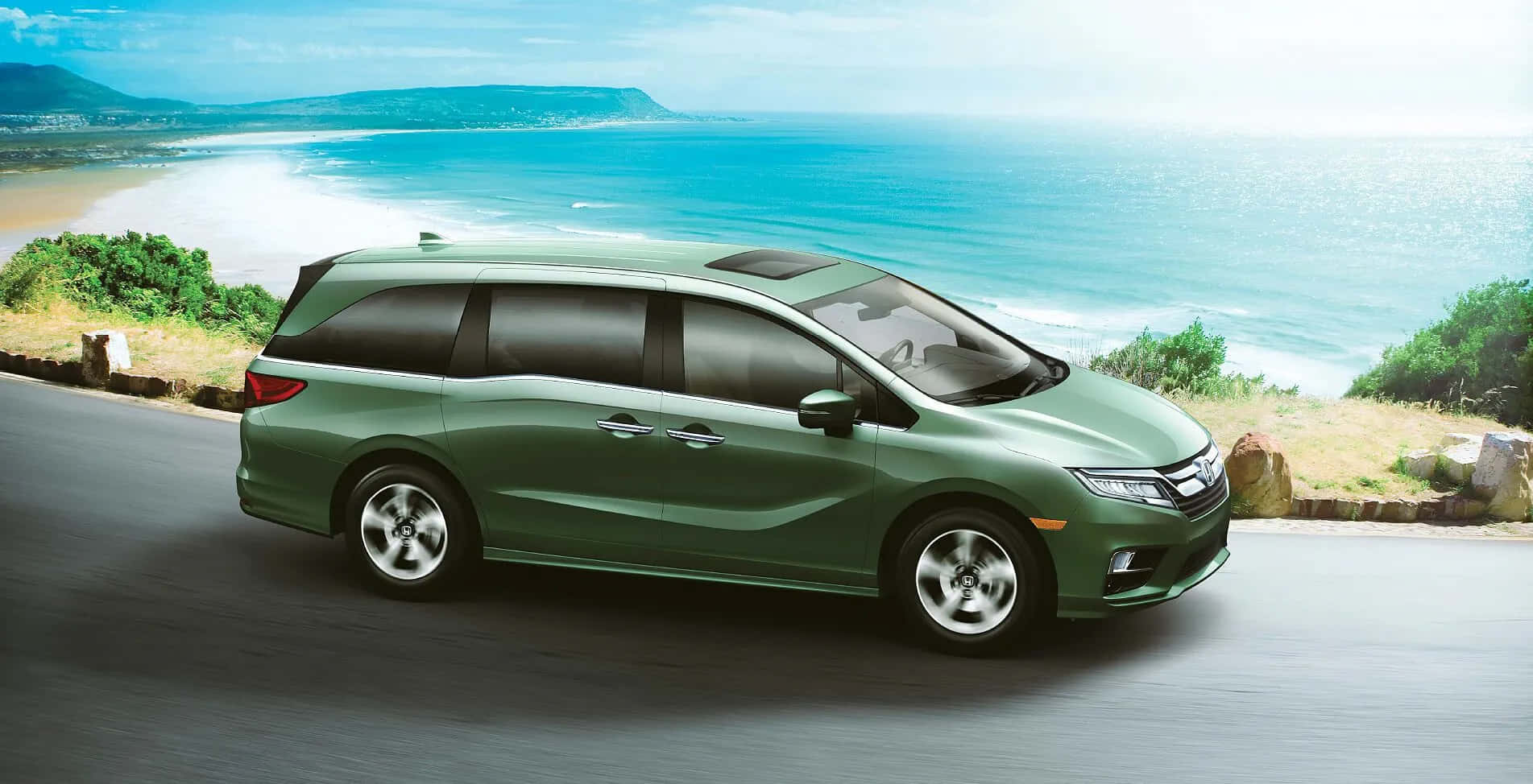 Honda Odyssey 桌布 壁紙 — 一架時尚的綠色小型貨車沿著海岸道路行駛，碧綠的海浪拍打著沙灘，天空湛藍明亮。