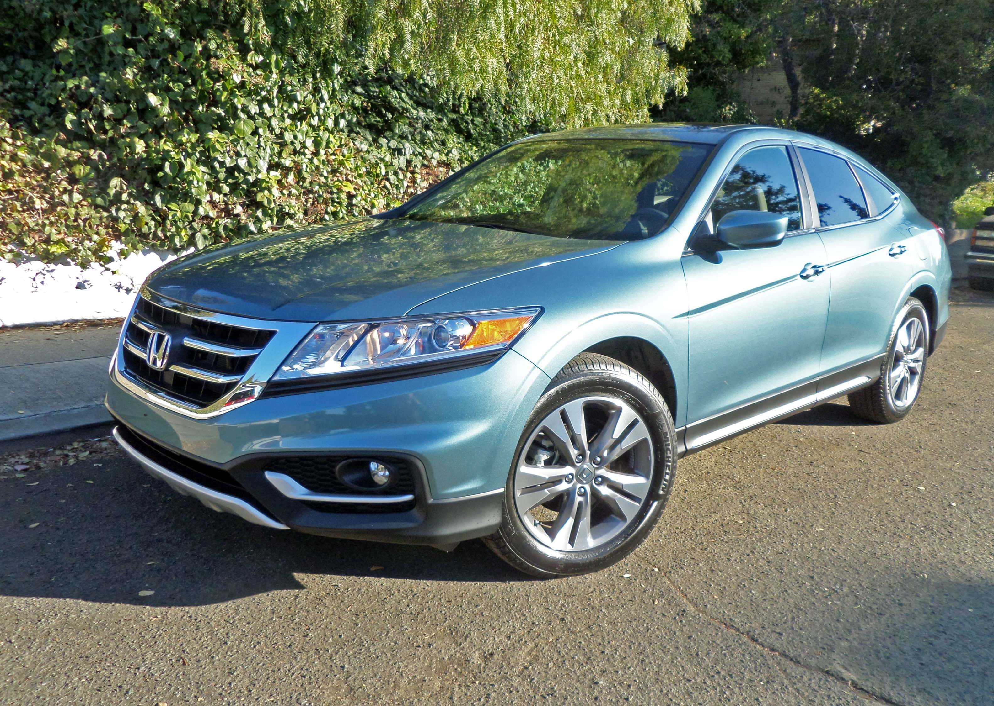 Honda Crosstour 桌布 壁紙 — 一架時尚的淺藍色本田 Crosstour SUV 停泊在陽光普照的瀝青車道上，旁邊是茂密的綠色樹籬。