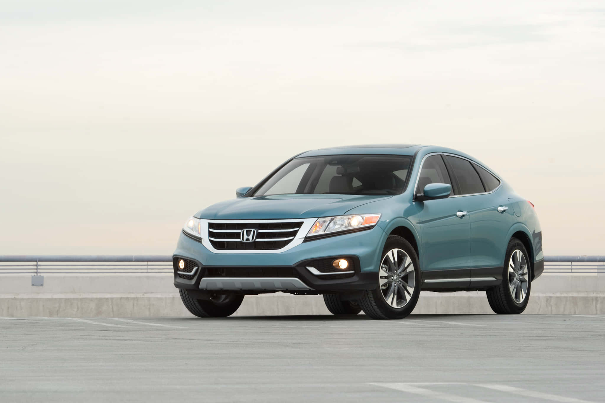 Honda Crosstour 桌布 壁紙 — 一架時尚的淺藍色本田SUV停在混凝土天橋上，天空柔和灰色。