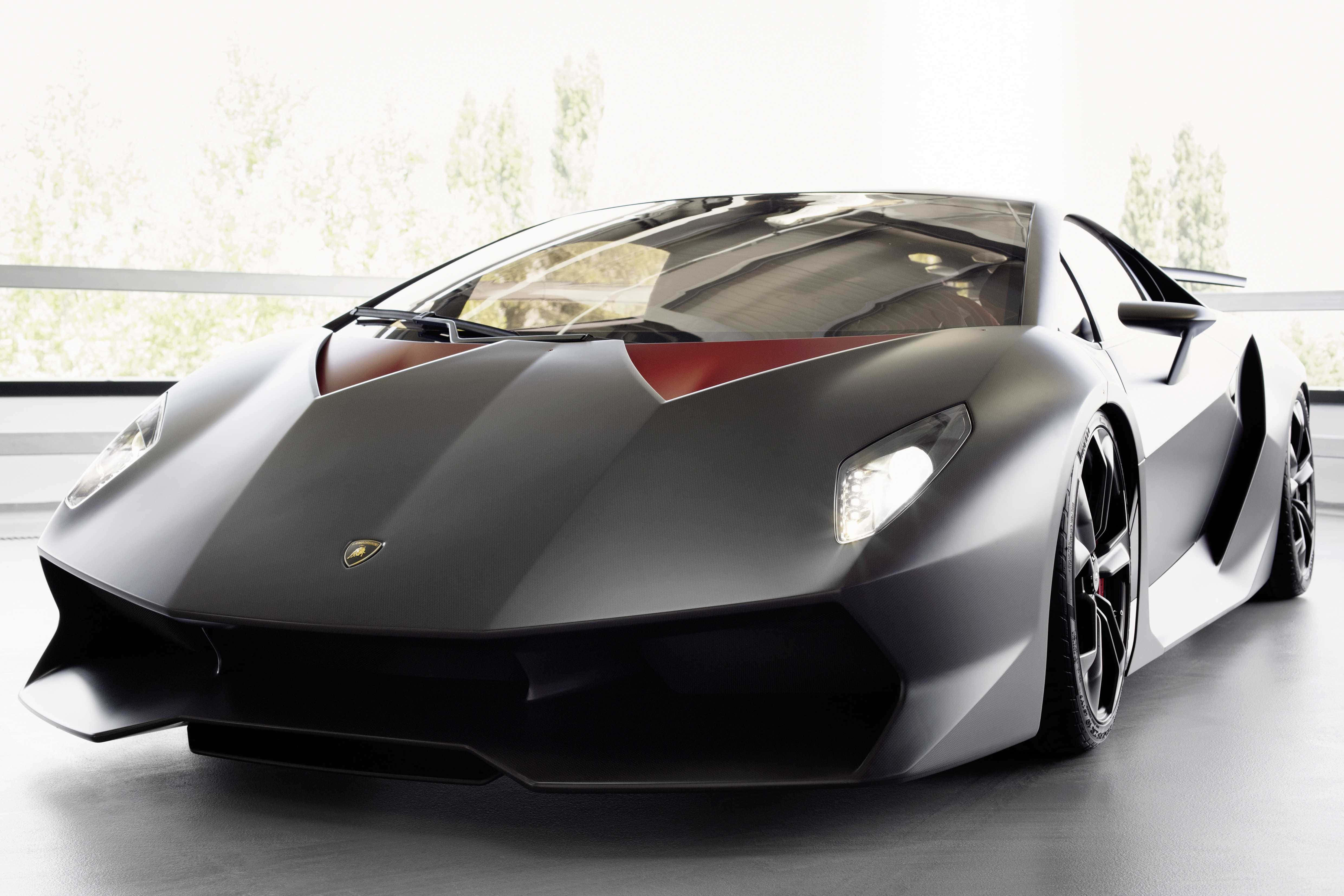 Lamborghini Sesto Elemento 桌布 壁紙 — 一輛時尚的啞光黑色林寶堅尼跑車帶有紅色點綴，在一個明亮現代、有大窗戶的工作室中展示。