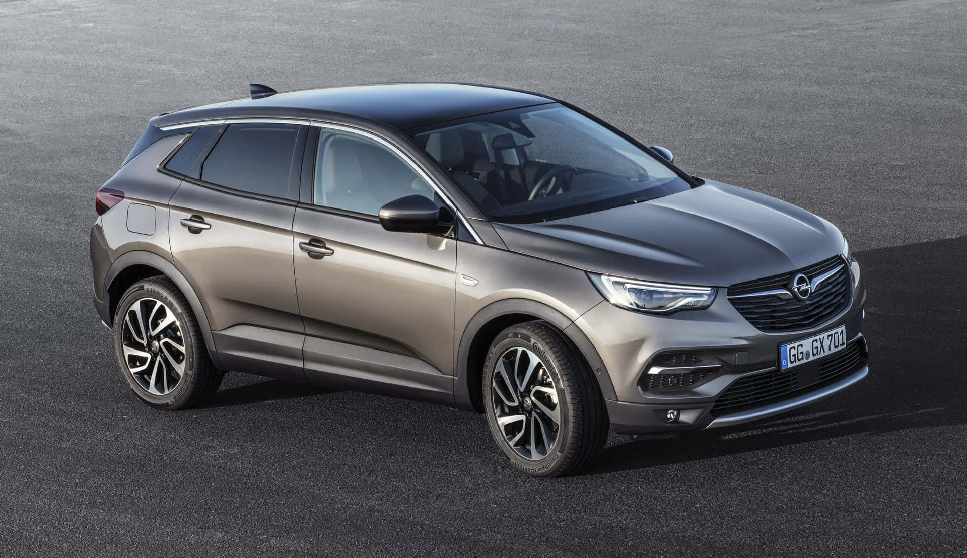 Opel Grandland X 桌布 壁紙 — 一輛時尚金屬灰色歐寶Grandland X SUV在明亮日光下停泊在平滑的瀝青路面上。