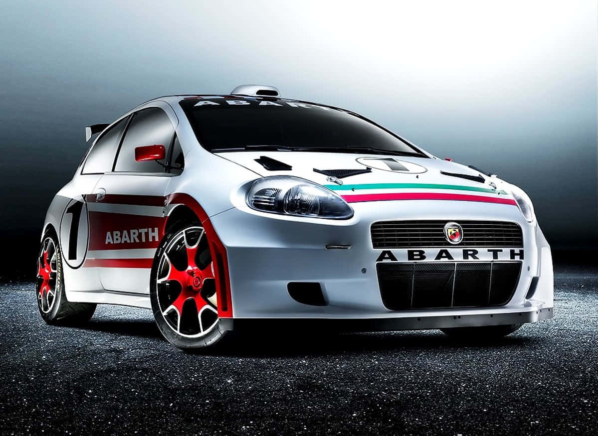 Fiat Punto 桌布 壁紙 — 一輛流線型的銀色 Abarth 拉力賽車，帶有紅色點綴和意大利三色條紋，在深色瀝青表面上於攝影棚燈光下閃閃發光。