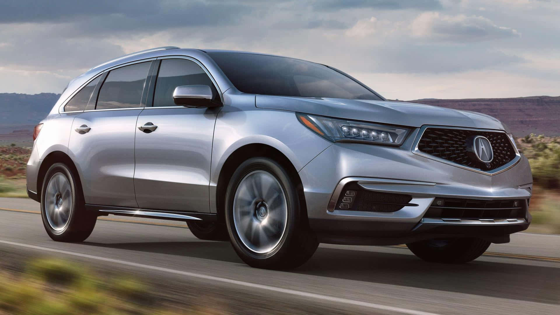 Acura Mdx 桌布 壁紙 — 一架時尚的銀色Acura SUV在陰天下行駛於沙漠高速公路，帶有模糊的動態效果。