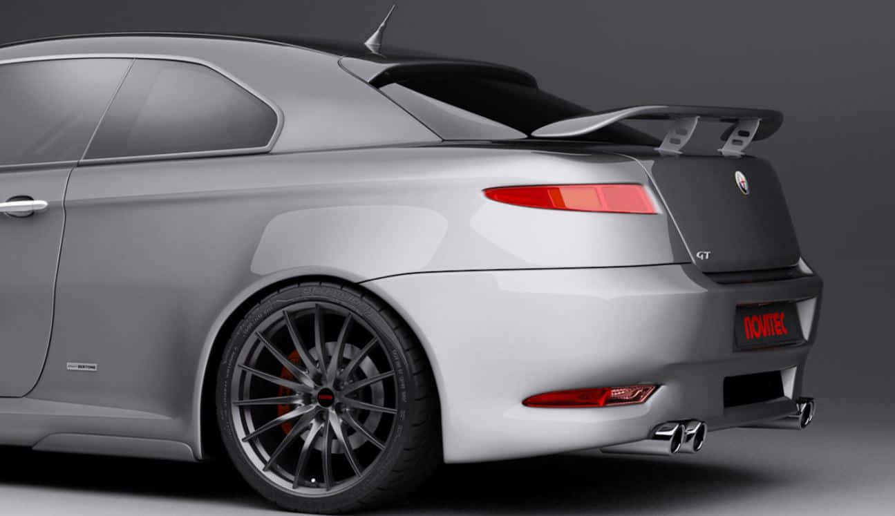 Alfa Romeo Gt 桌布 壁紙 — 一輛時尚的銀色Alfa Romeo GT跑車，配備黑色後擾流板和紅色尾燈，在攝影棚燈光下展示。