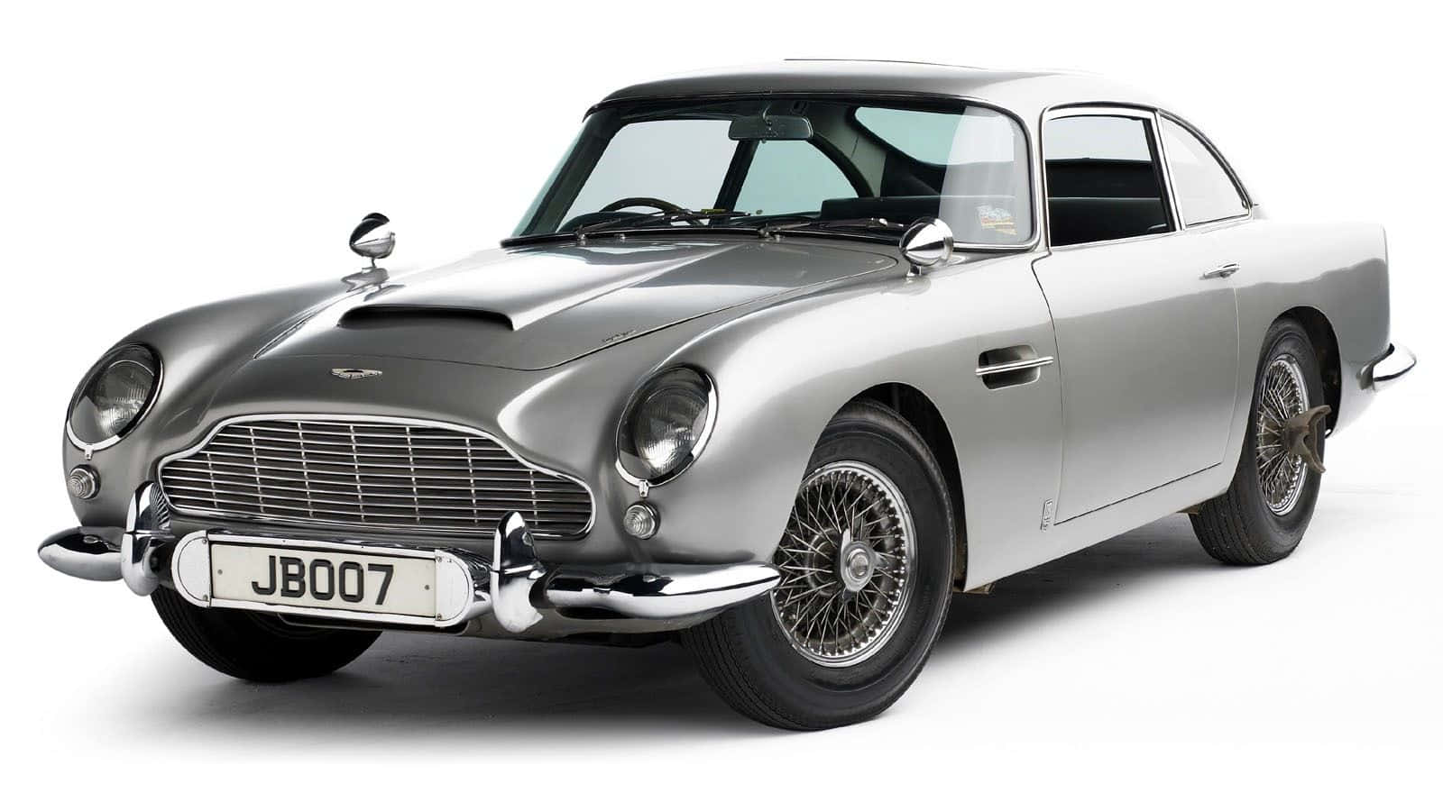 Aston Martin Db5 桌布 壁紙 — 一架流線型銀色Aston Martin DB5經典車，帶有鍍鉻裝飾和鋼絲輪，擺放在乾淨的白色背景前。