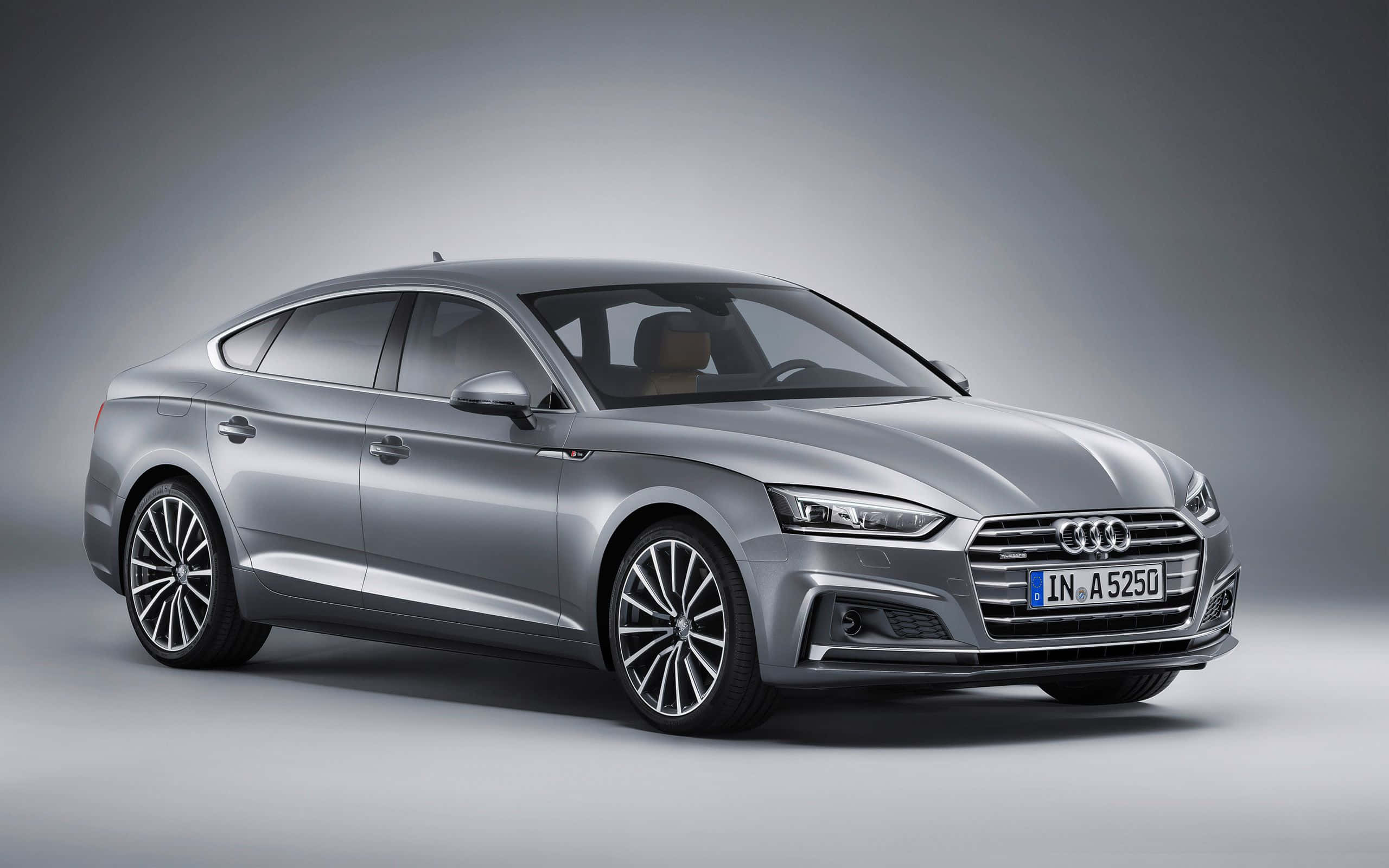 Audi A5 桌布 壁紙 — 一輛時尚的銀色奧迪A5 Sportback在簡約灰色背景的影樓燈光下閃閃發光。
