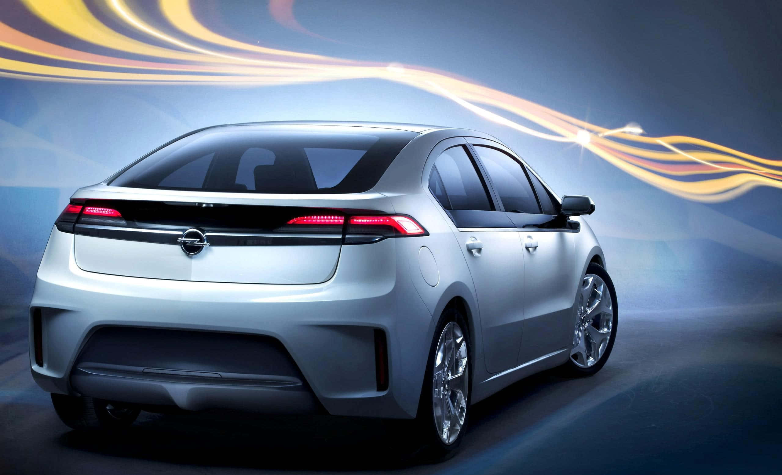 Opel Ampera 桌布 壁紙 — 從後方觀看的時尚銀色電動車，帶有發光的紅色尾燈和動態金色光條，在未來主義的工作室環境中。
