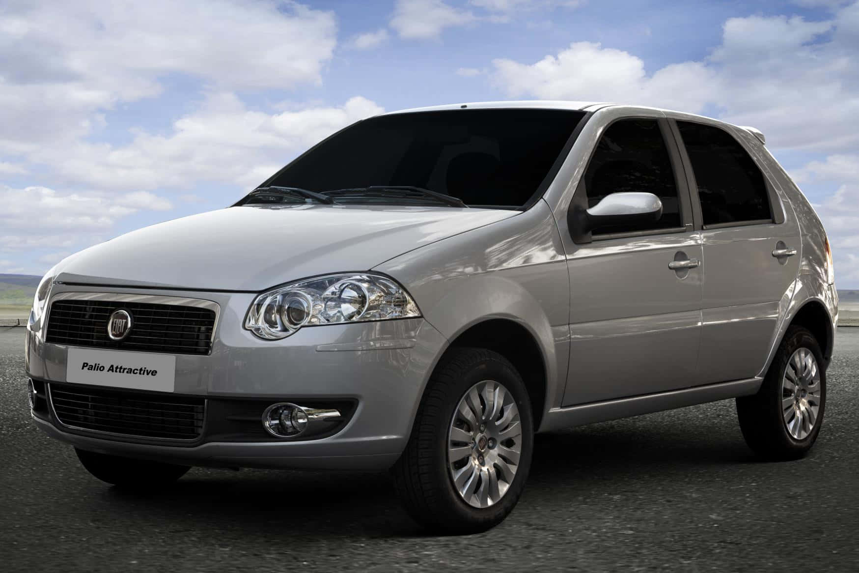 Fiat Palio 桌布 壁紙 — 一輛時尚的銀色 Fiat Palio Attractive 掀背車停在瀝青路上，上方是明亮的藍天和蓬鬆的白雲。