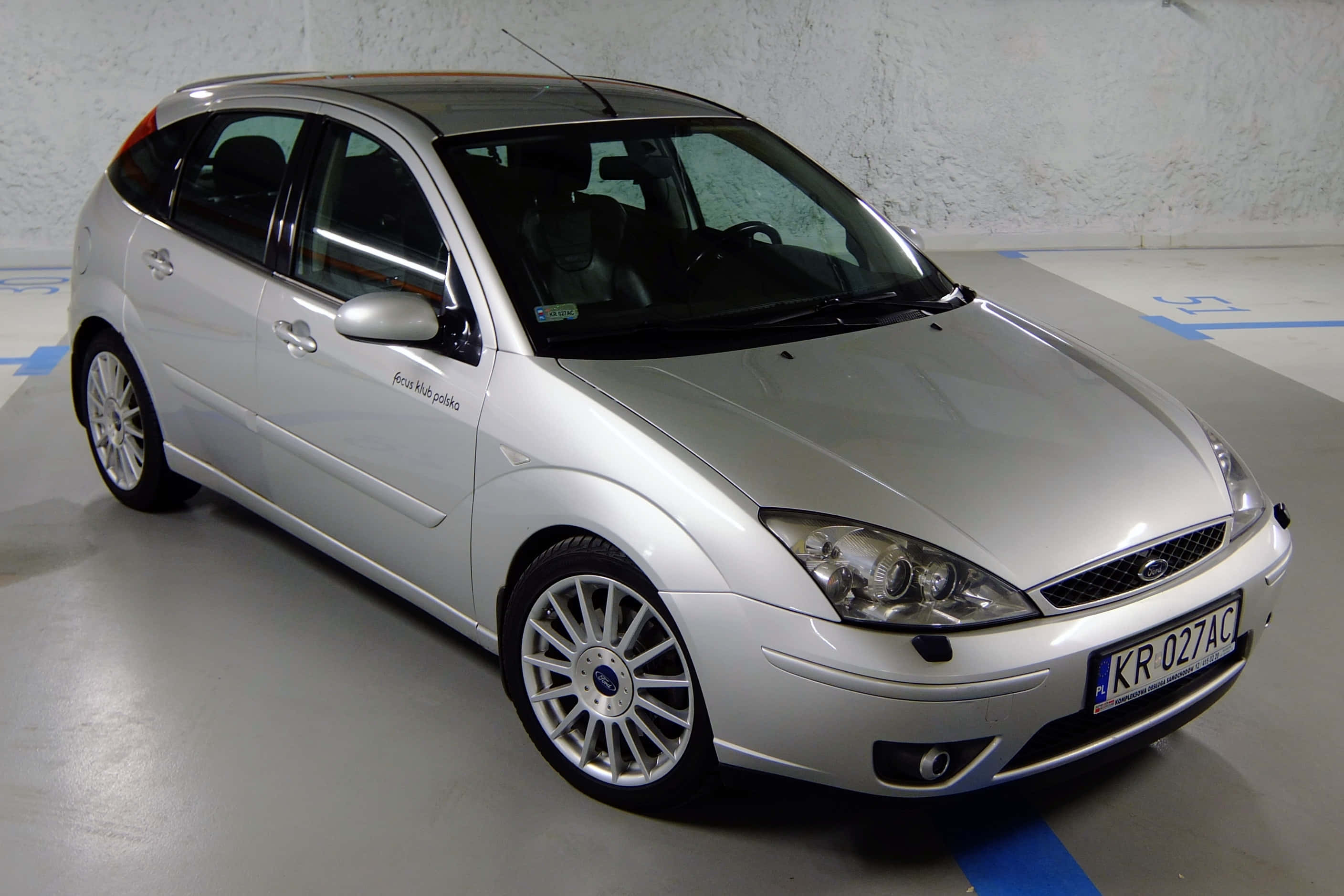 Ford Focus 桌布 壁紙 — 一輛時尚的銀色福特福克斯掀背車停在室內有標記的地板上，牆壁有紋理。