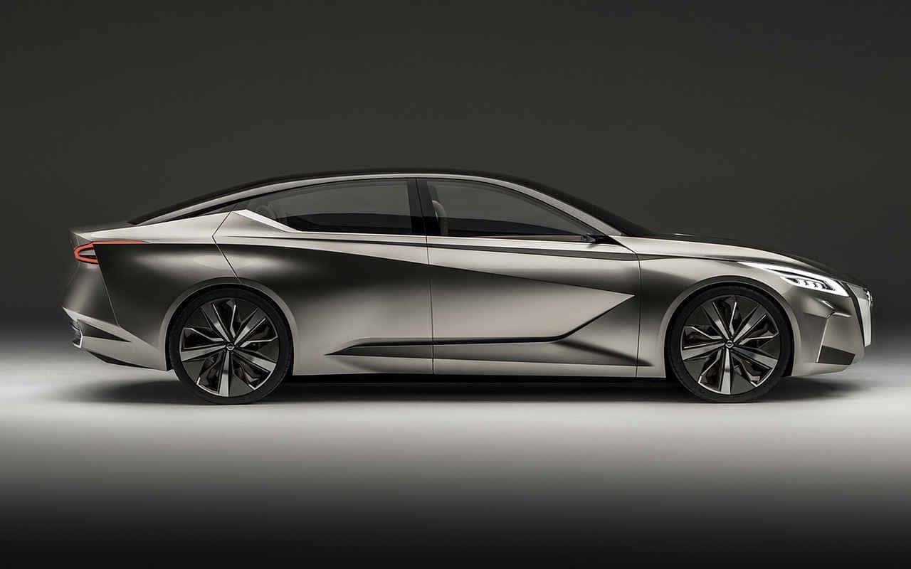 Nissan Altima 桌布 壁紙 — 一輛時尚的銀色未來感轎車，帶有銳利的棱角線條和發光的車頭燈，矗立在簡約的工作室環境中。