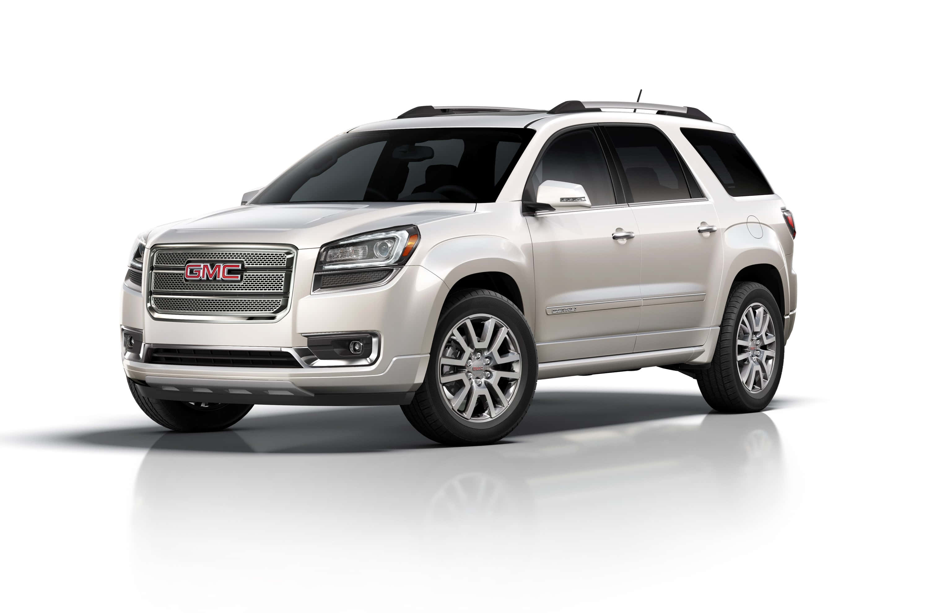 Gmc Acadia 桌布 壁紙 — 一輛時尚的銀色GMC Acadia SUV在乾淨的攝影棚中展示，配有反射地板和柔和燈光。