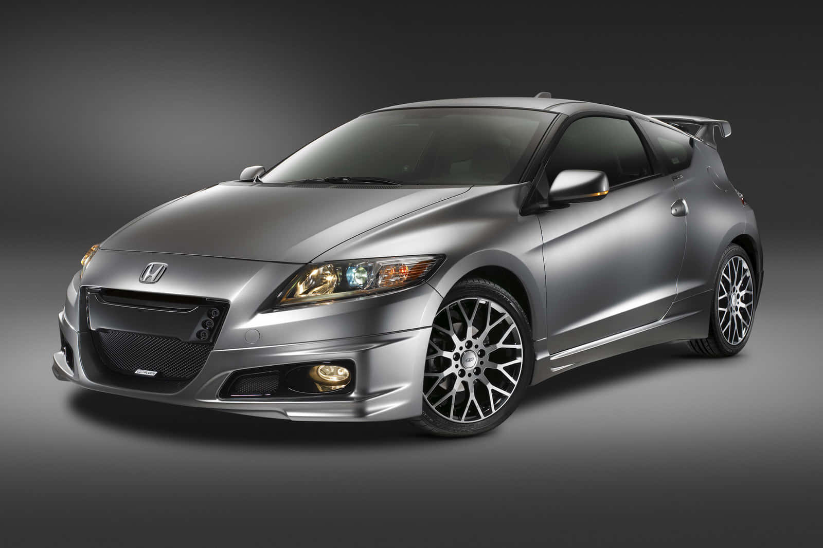Honda Cr-z 桌布 壁紙 — 一部型格銀色本田CR-Z運動轎跑車，配備訂製輪圈和後擾流板，在深色工作室背景下展示。