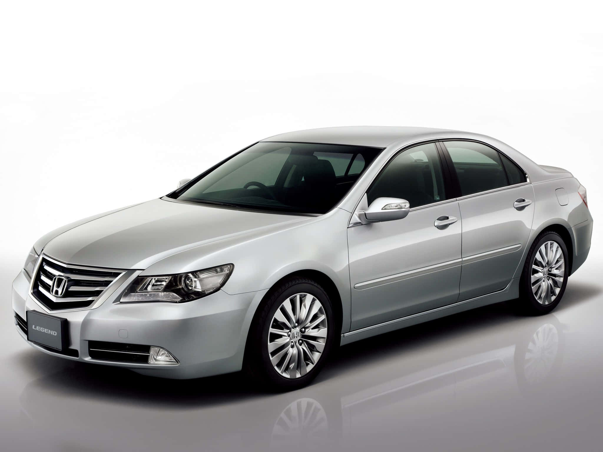 Honda Legend 桌布 壁紙 — 一輛時尚的銀色本田Legend轎車在攝影棚燈光下，在反光的白色表面上閃閃發光。