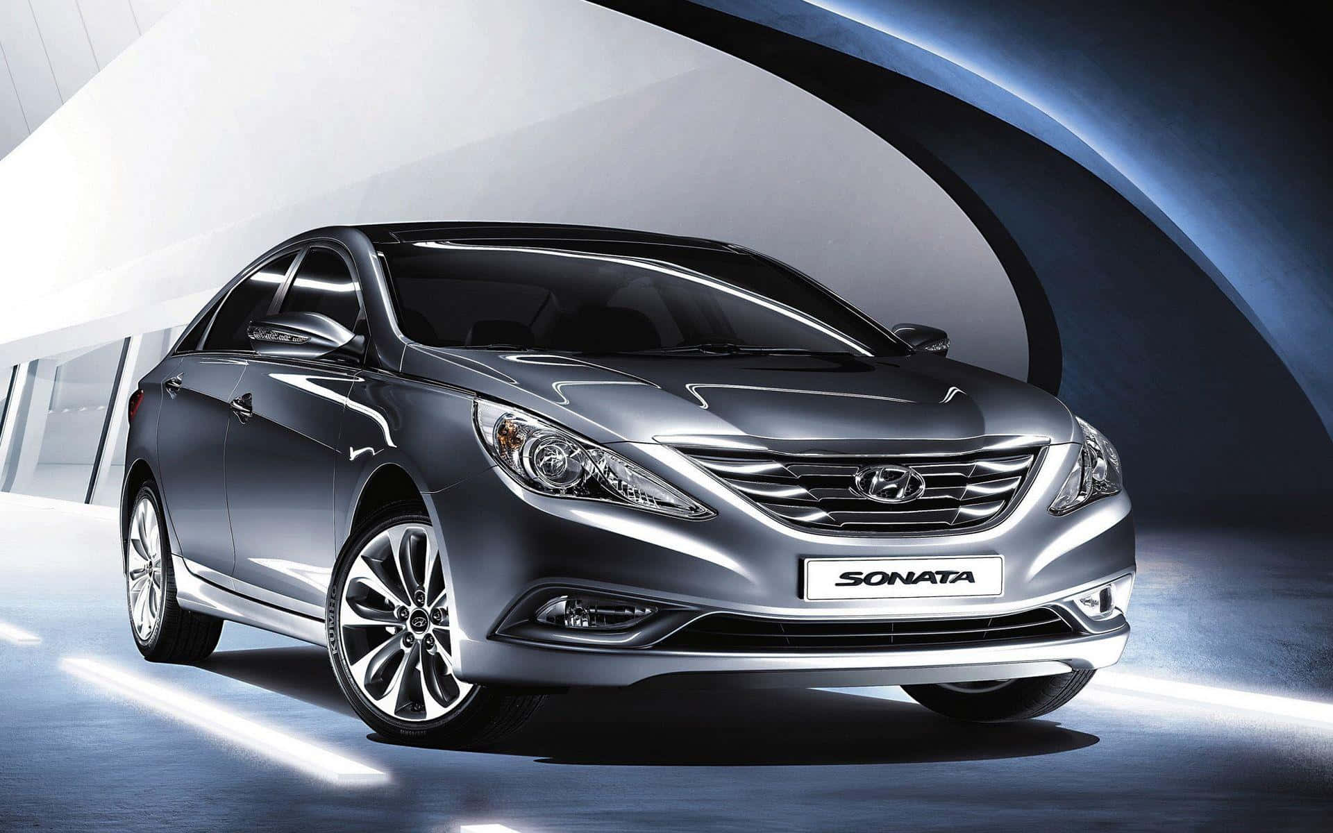 Hyundai Sonata 桌布 壁紙 — 一輛時尚的銀色現代索納塔轎車在未來風格的彎曲隧道場景中，於攝影棚燈光下閃閃發光。