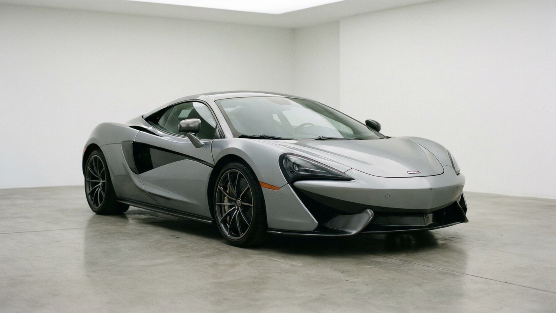 Mclaren 570s 桌布 壁紙 — 一輛帶有黑色裝飾的時尚銀色McLaren跑車，在極簡白色工作室中展示，地板為拋光混凝土。