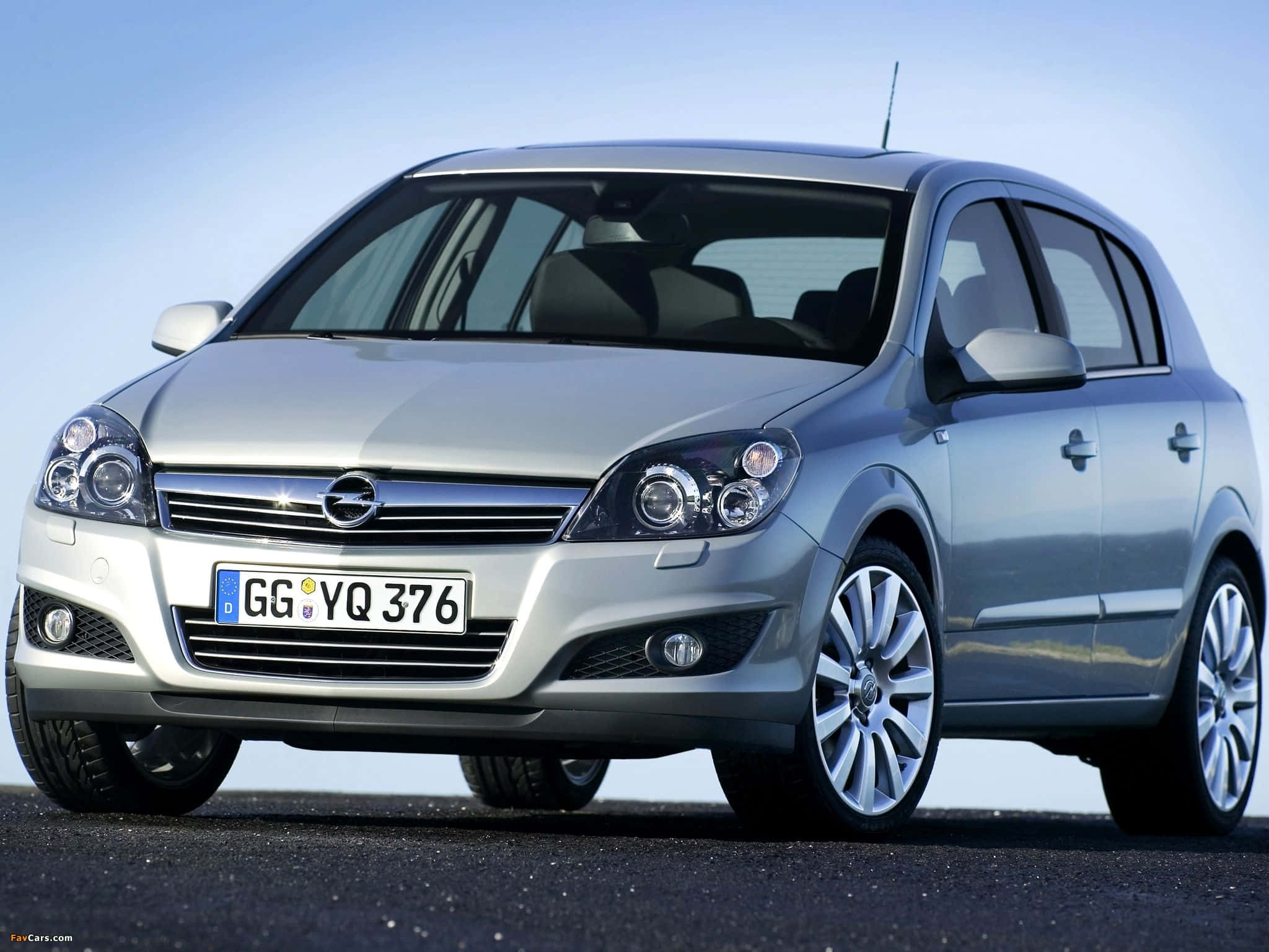 Opel Astra 桌布 壁紙 — 一輛時尚的銀色歐寶雅特掀背車停在瀝青路面上，天空清澈湛藍，光線明亮。