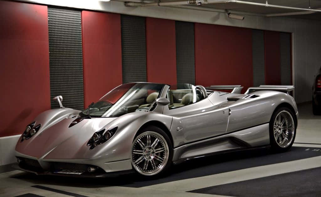 Pagani Zonda C12 Roadster 桌布 壁紙 — 一輛時尚的銀色Pagani Zonda Roadster開篷跑車停放在現代車庫中，車庫有紅色和灰色牆壁。