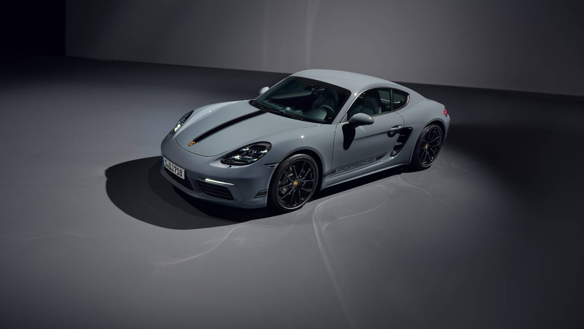 工作室環境中帶有黑色條紋的銀色保時捷718 Cayman。