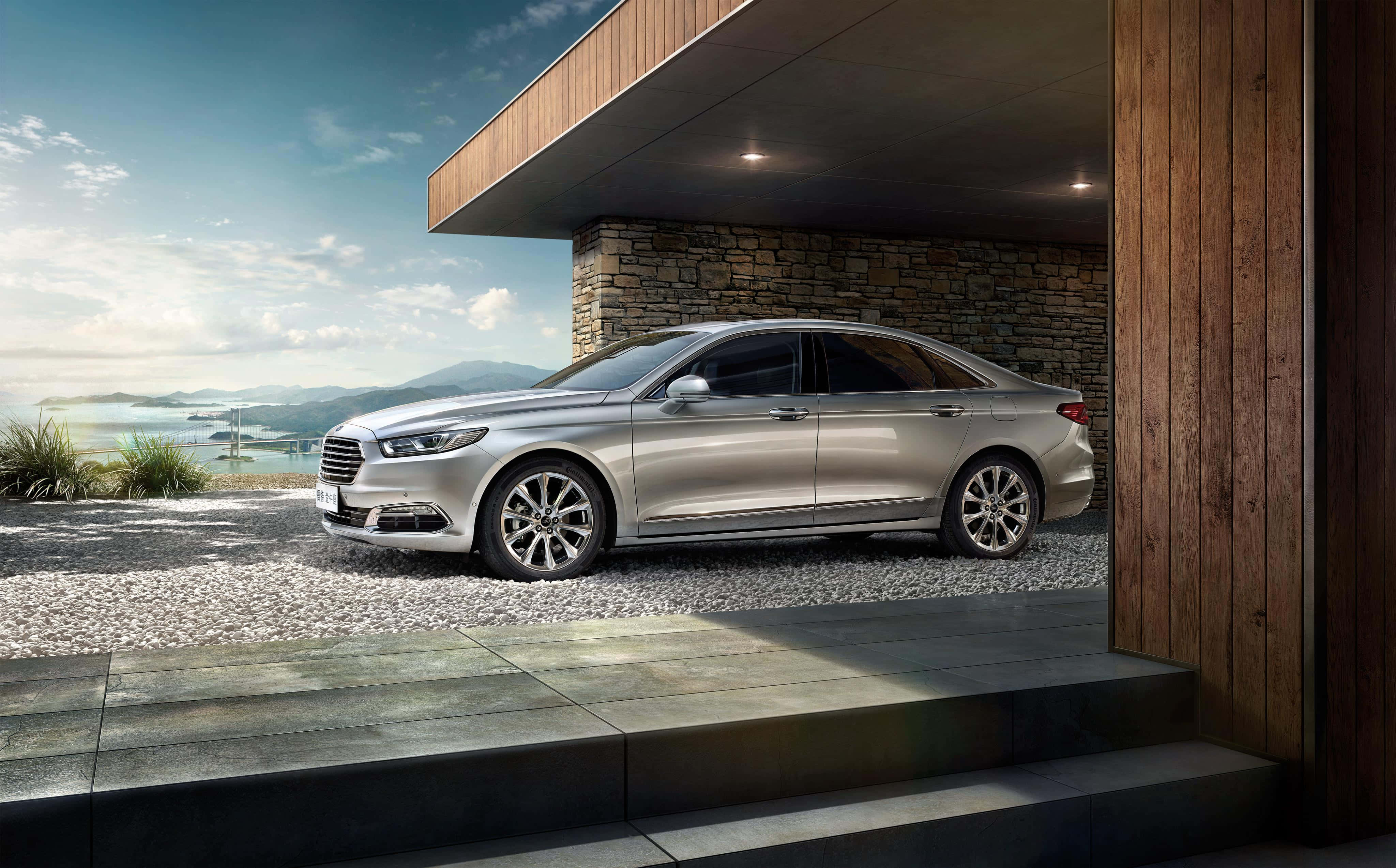 Ford Taurus 桌布 壁紙 — 一輛時尚的銀色轎車停放在現代木製懸挑下，俯瞰著擁有遠處山脈和水的海岸景觀。