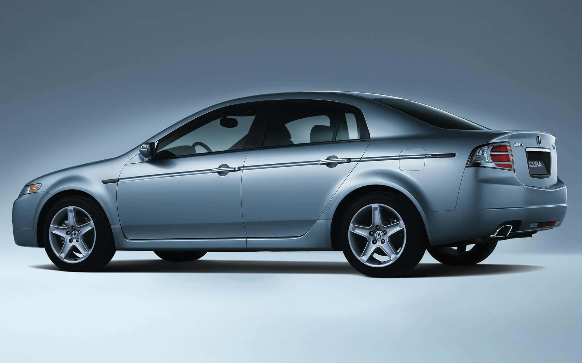 Acura Tl 桌布 壁紙 — 一輛時尚的銀色轎車以側面輪廓展示，背景為漸變灰色工作室背景，光線柔和。