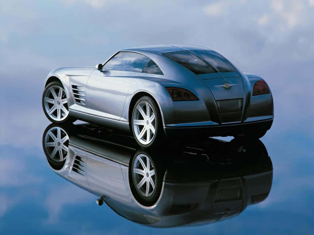 Chrysler Crossfire 桌布 壁紙 — 一輛時尚的銀色跑車漂浮在鏡面之上，映襯著其未來感設計，背景是陰雲密布的天空。