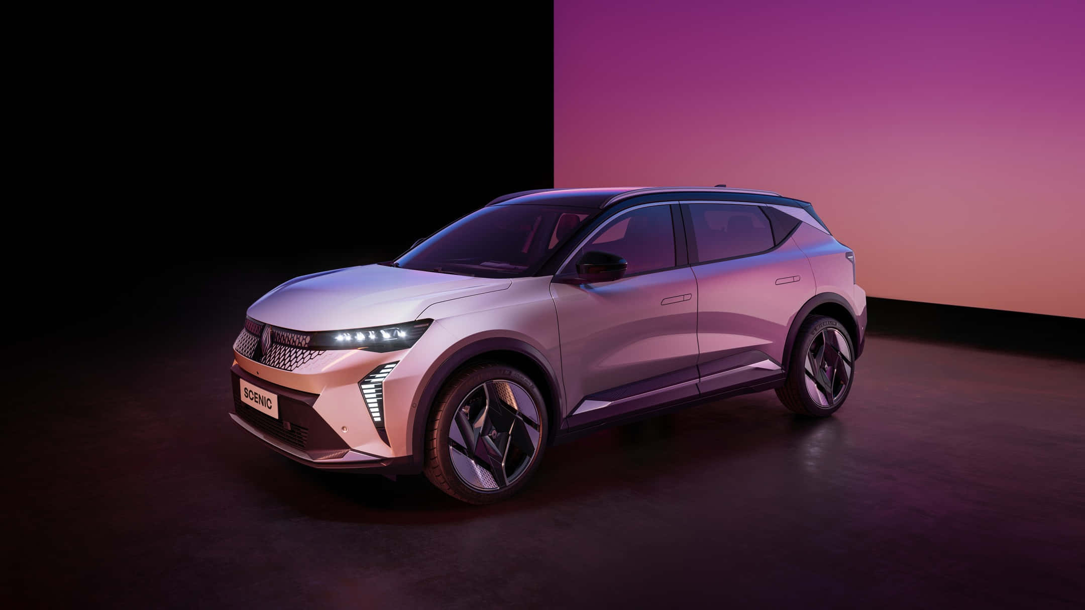 Renault Scenic 桌布 壁紙 — 一輛時尚的銀色SUV，配備發光頭燈，在紫色和橙色的漸變工作室背景前展示。