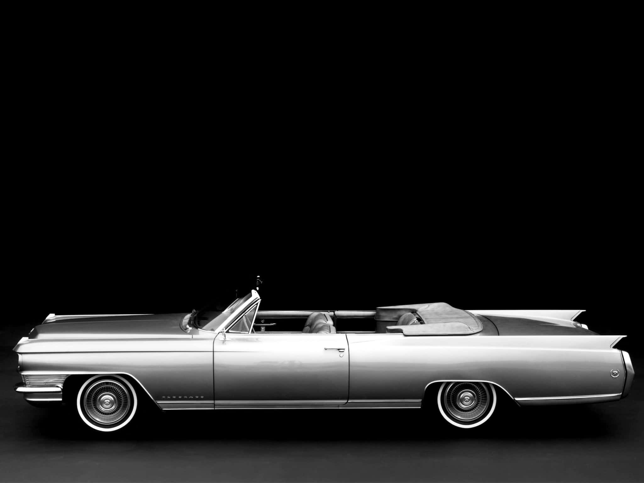 Cadillac Fleetwood 桌布 壁紙 — 一輛時尚的復古敞篷車在單色調中閃耀，以純黑背景襯托，展現其經典曲線和鍍鉻細節。