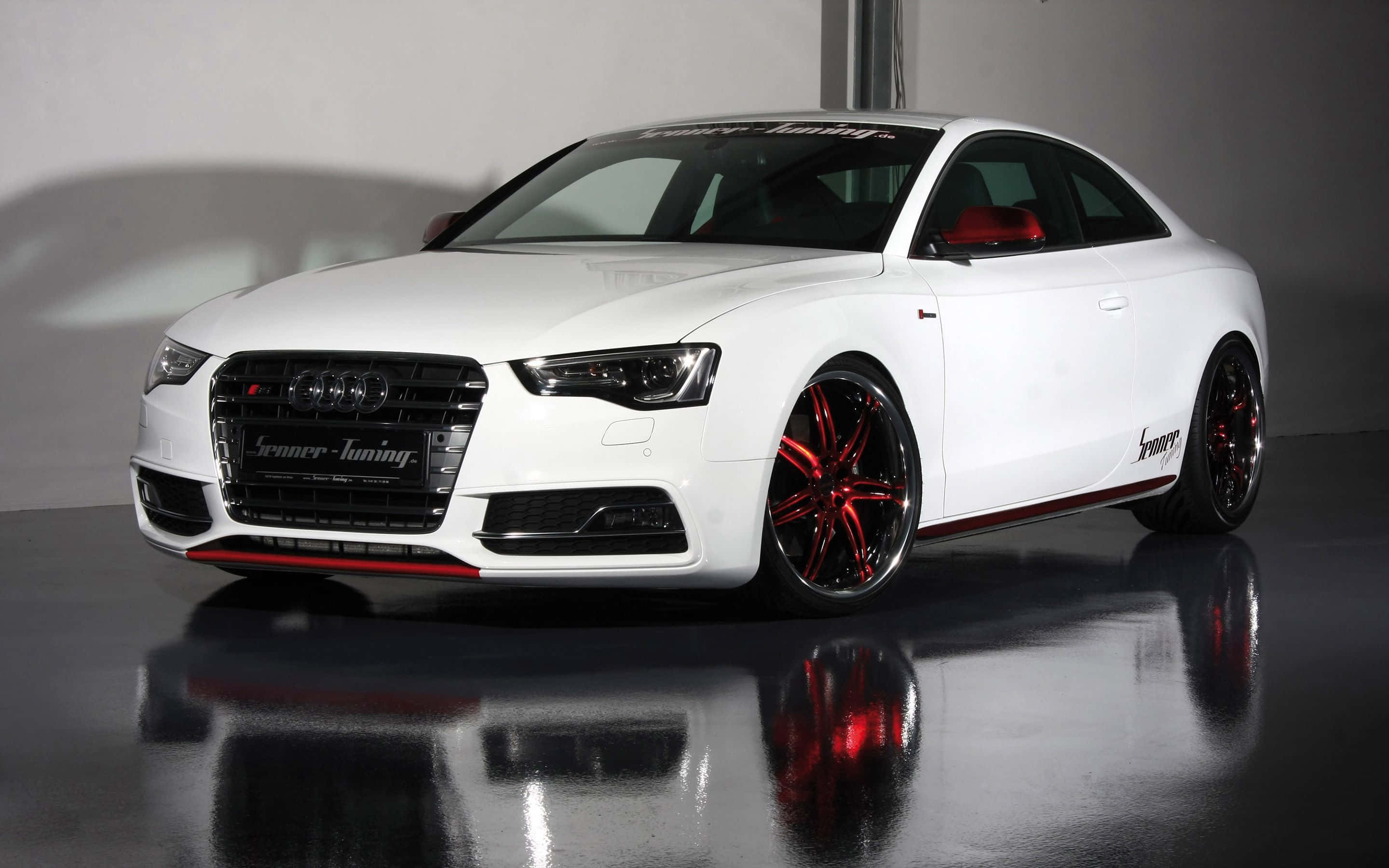 Audi S5 桌布 壁紙 — 一輛時尚的白色奧迪雙門轎跑車，帶有紅色點綴和定制輪圈，在攝影棚燈光下閃耀於反光地板。