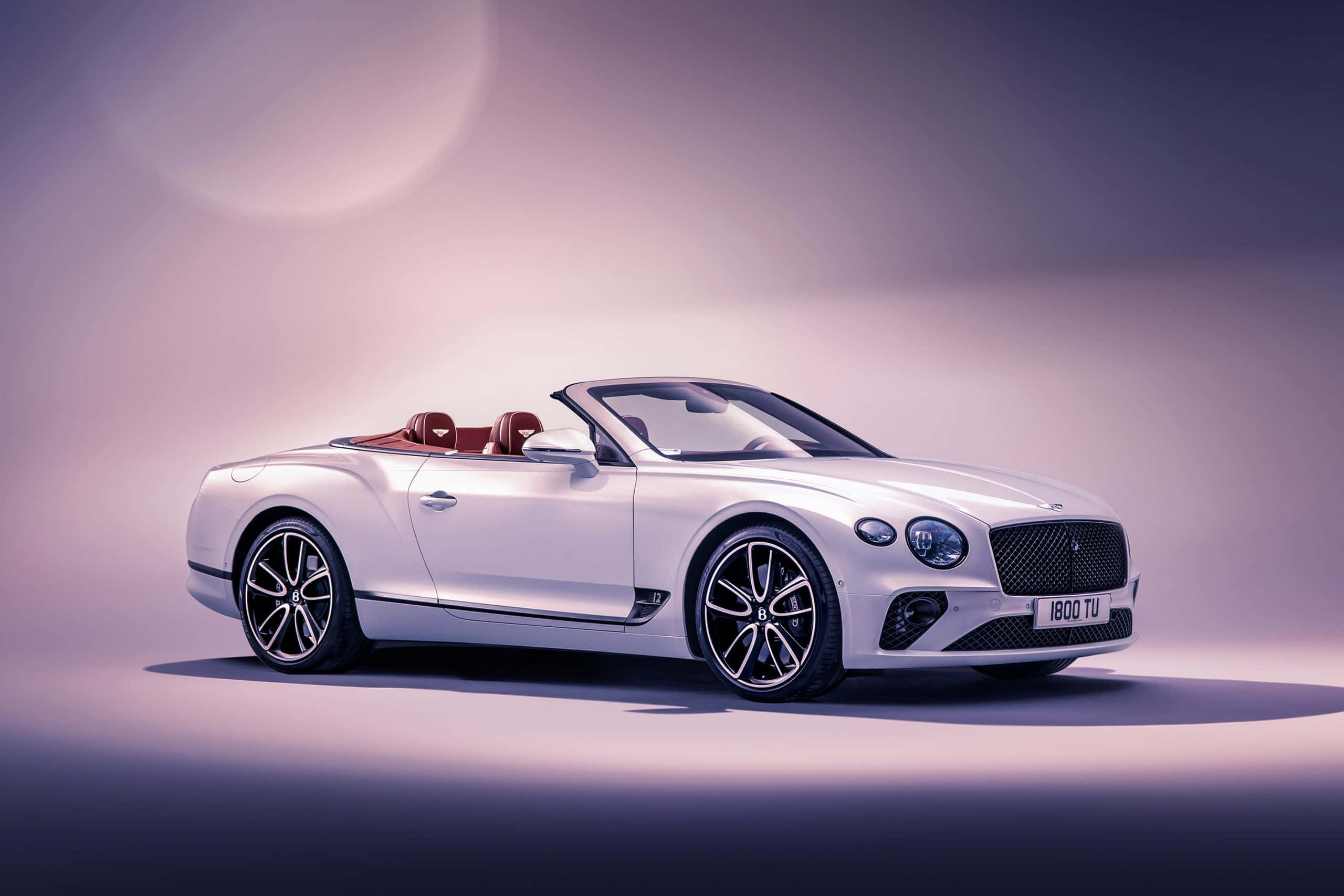 Bentley Continental Gt 桌布 壁紙 — 一輛時尚的白色賓利敞篷車配紅色真皮座椅，在柔和的紫色漸變工作室背景中展示。