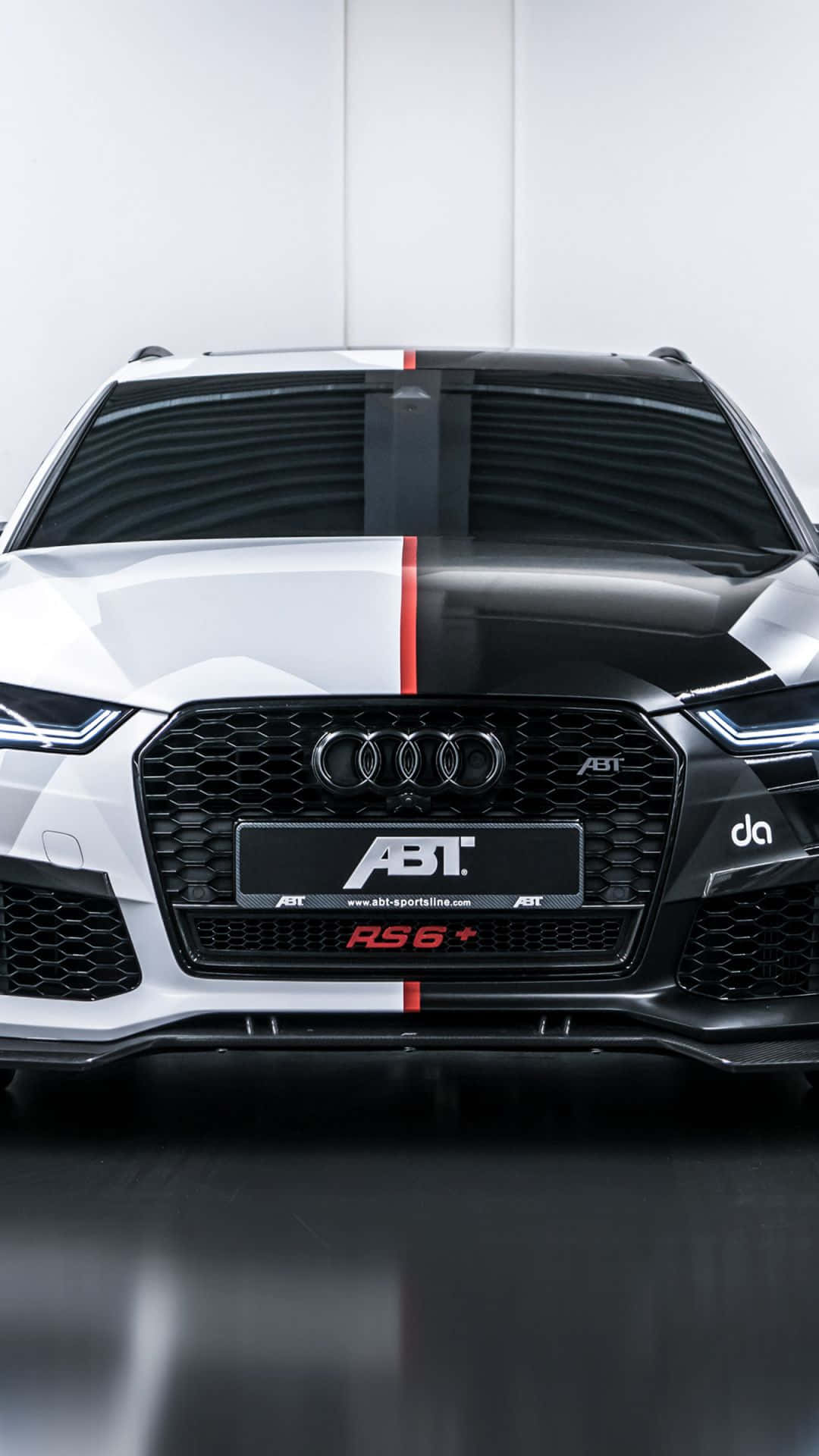Audi Rs6 桌布 壁紙 — 一輛時尚的白色和黑色ABT改裝奧迪RS6+跑車，帶有紅色賽車條紋，在簡約的攝影棚環境中展示。