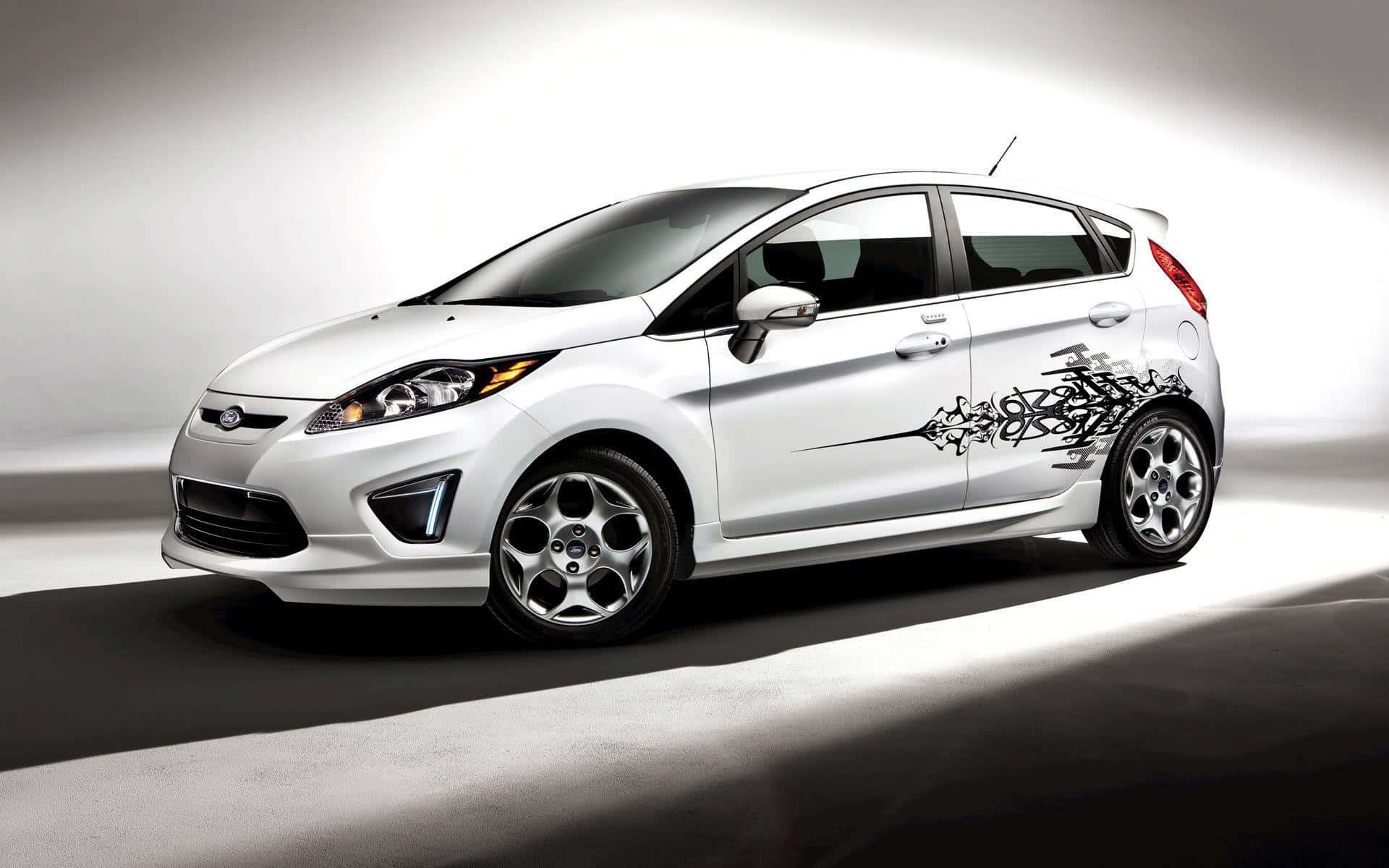 Ford Fiesta 桌布 壁紙 — 一部時尚的白色福特Fiesta，帶有醒目的黑色部落圖案貼紙，在戲劇性的工作室燈光下滑行，投射出銳利的陰影。