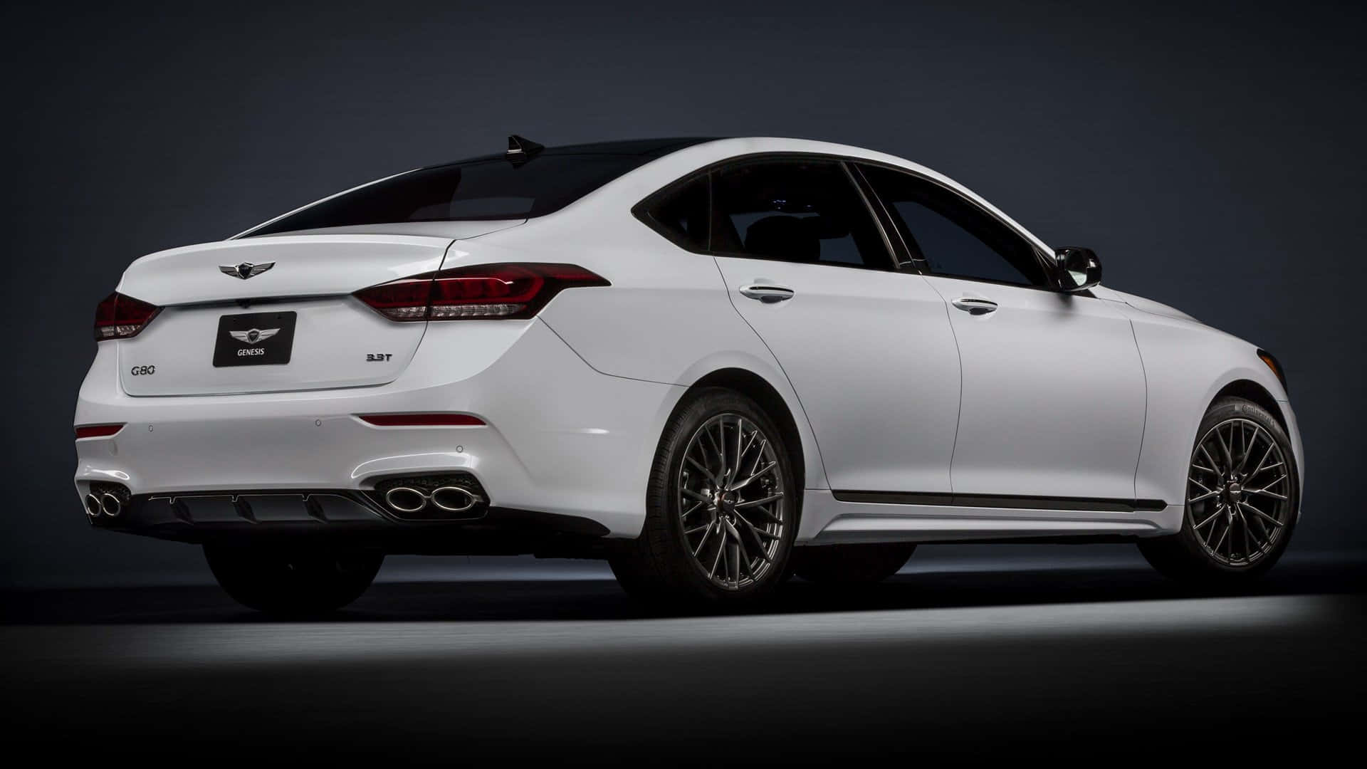 Genesis G80 桌布 壁紙 — 一輛時尚的白色Genesis G80轎車以後方四分之三視角展示，背景為昏暗的攝影棚，帶有戲劇性燈光。
