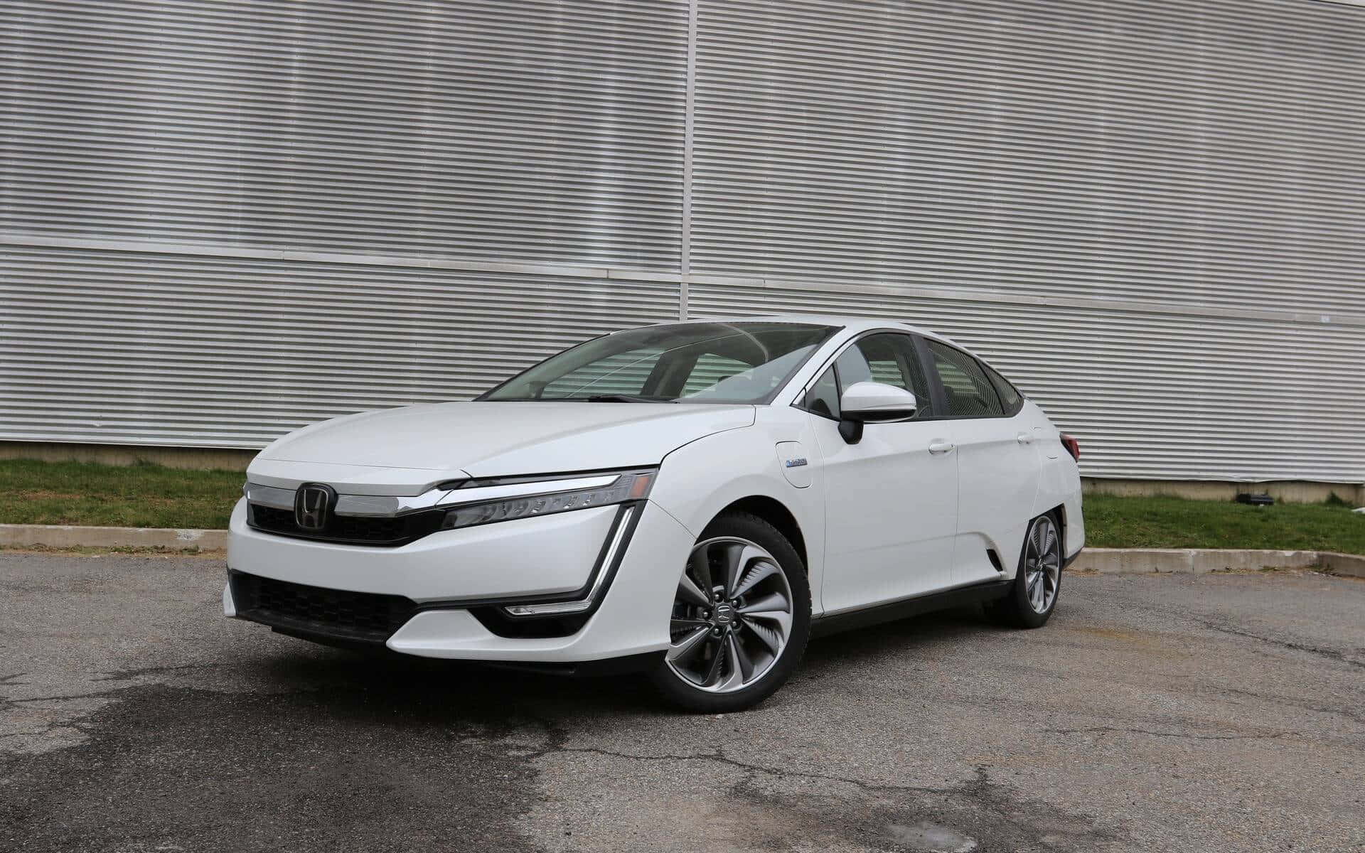 Honda Clarity 桌布 壁紙 — 一輛時尚的白色本田電動轎車停在瀝青路上，前面是波紋金屬牆。